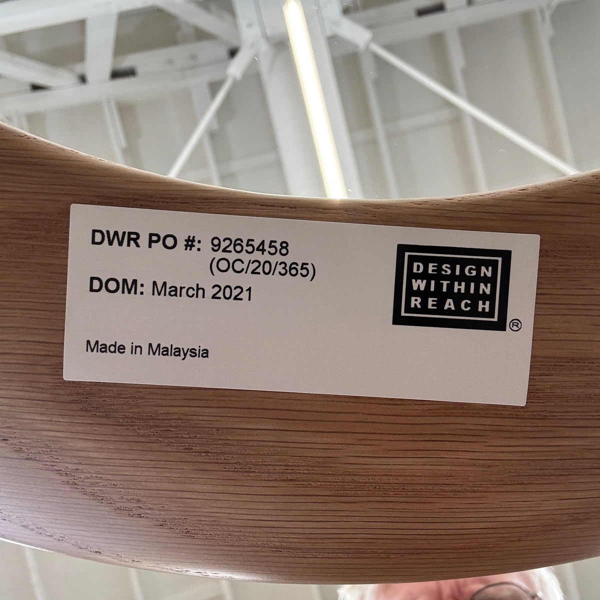 The DWR Port Side Table by DWR features a small, round design with three solid American oak legs and a clear glass top, shown against a plain white background.
