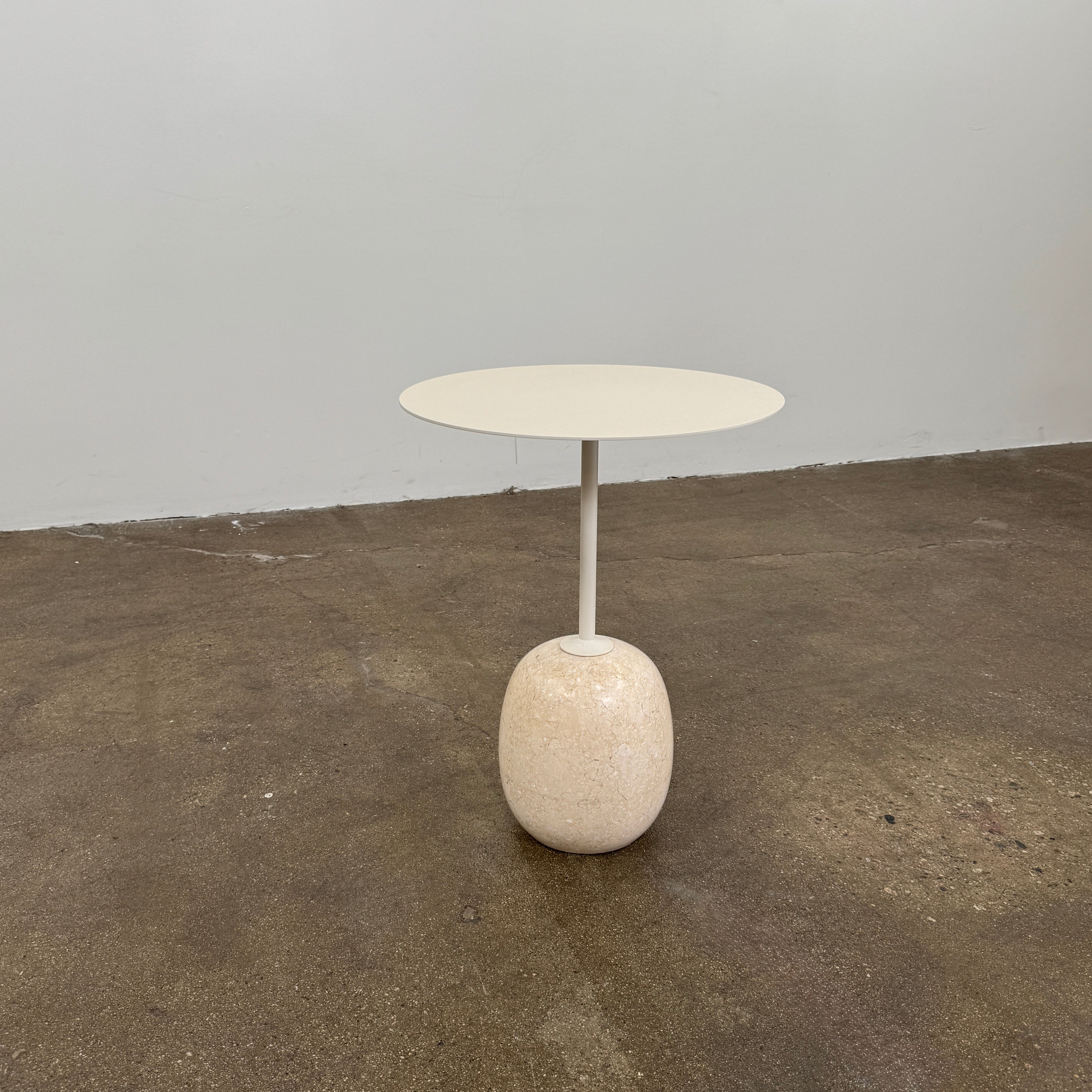 The &Tradition Crema Diva Marble Lato Side Table by &Tradition features a thin, light-colored round top supported by a slender vertical stem and rests on a smooth oval base crafted from Crema Diva marble, all set against a plain white background. Inspired by the iconic Lato Side Table design, this piece combines elegance with timeless style.
