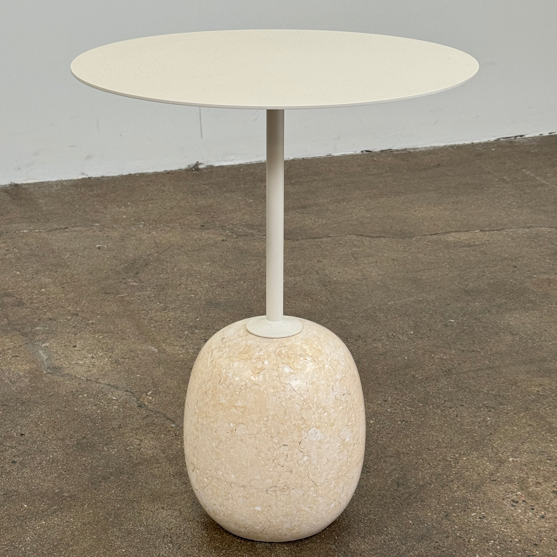 The &Tradition Crema Diva Marble Lato Side Table by &Tradition features a thin, light-colored round top supported by a slender vertical stem and rests on a smooth oval base crafted from Crema Diva marble, all set against a plain white background. Inspired by the iconic Lato Side Table design, this piece combines elegance with timeless style.