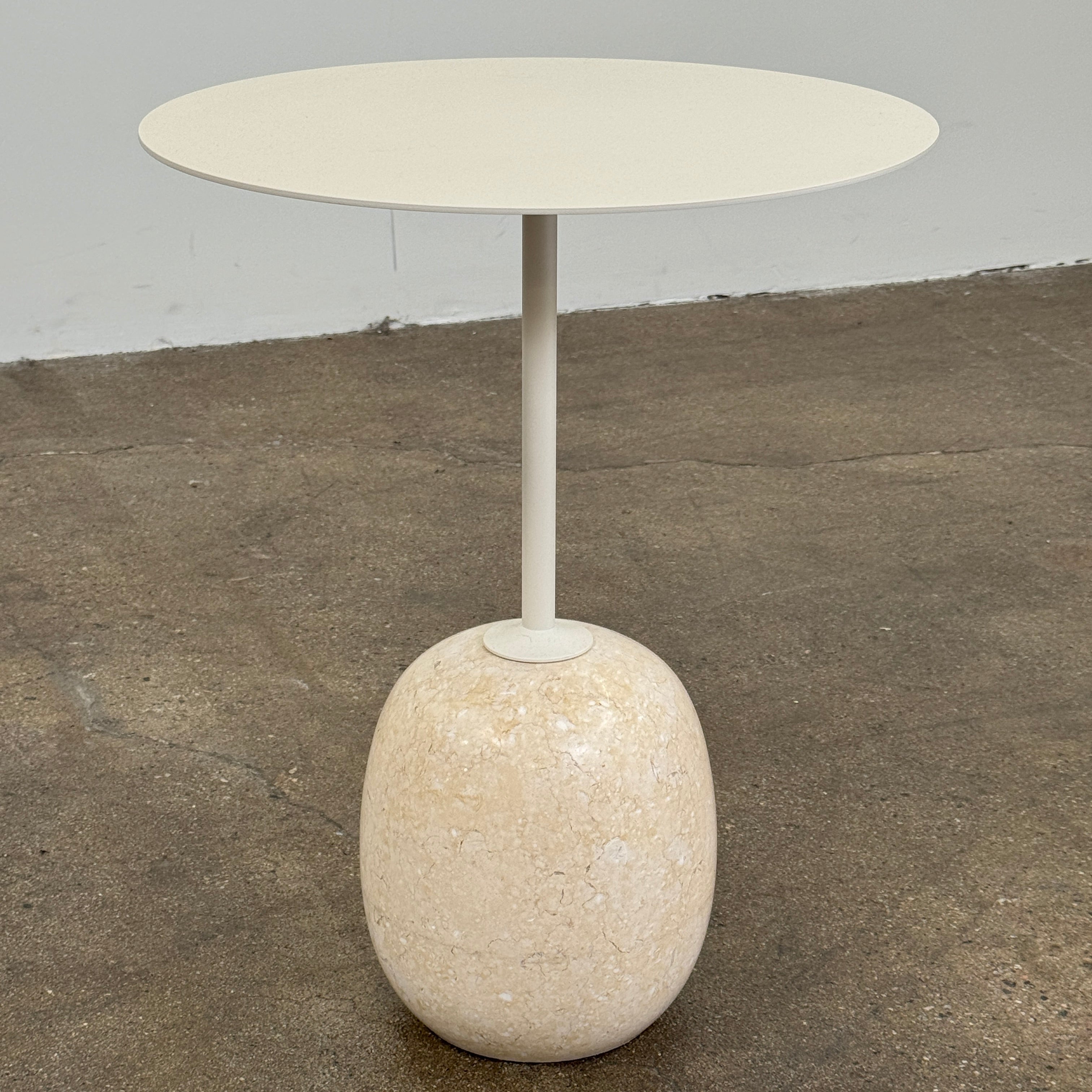 The &Tradition Crema Diva Marble Lato Side Table by &Tradition features a thin, light-colored round top supported by a slender vertical stem and rests on a smooth oval base crafted from Crema Diva marble, all set against a plain white background. Inspired by the iconic Lato Side Table design, this piece combines elegance with timeless style.
