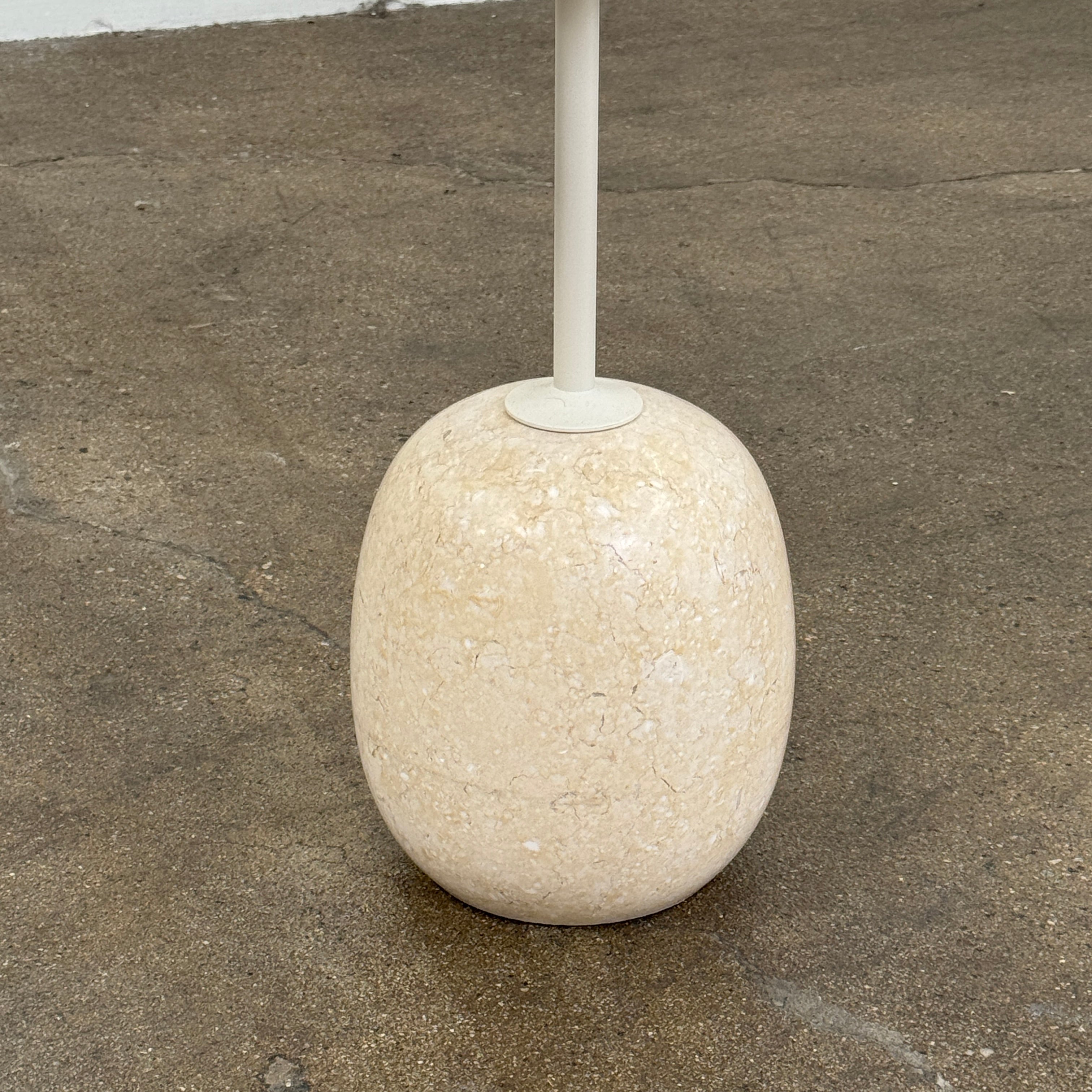 The &Tradition Crema Diva Marble Lato Side Table by &Tradition features a thin, light-colored round top supported by a slender vertical stem and rests on a smooth oval base crafted from Crema Diva marble, all set against a plain white background. Inspired by the iconic Lato Side Table design, this piece combines elegance with timeless style.