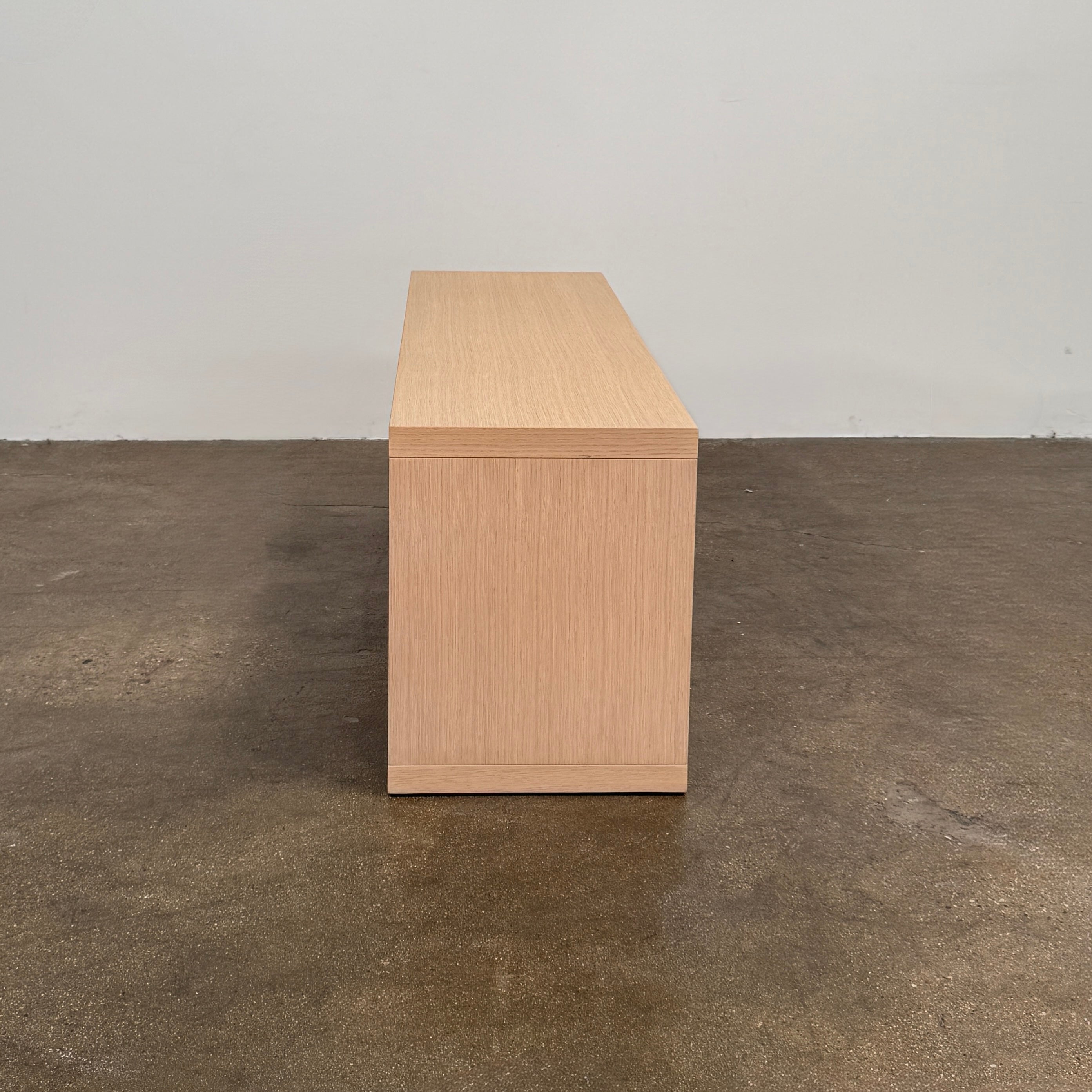 The B&B Italia Frank Low Console by B&B Italia rests on a polished concrete floor against a plain white wall.
