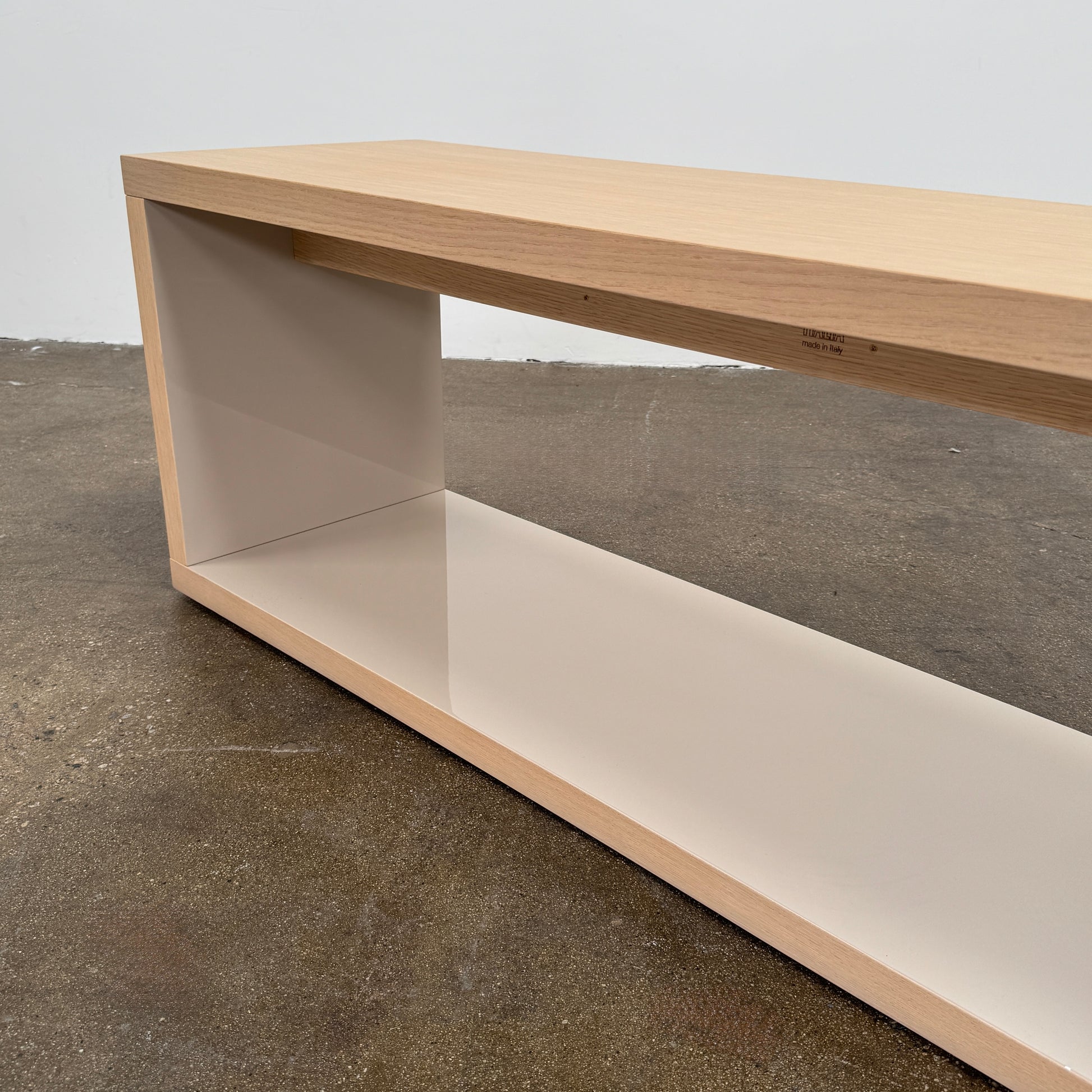 The B&B Italia Frank Low Console by B&B Italia rests on a polished concrete floor against a plain white wall.