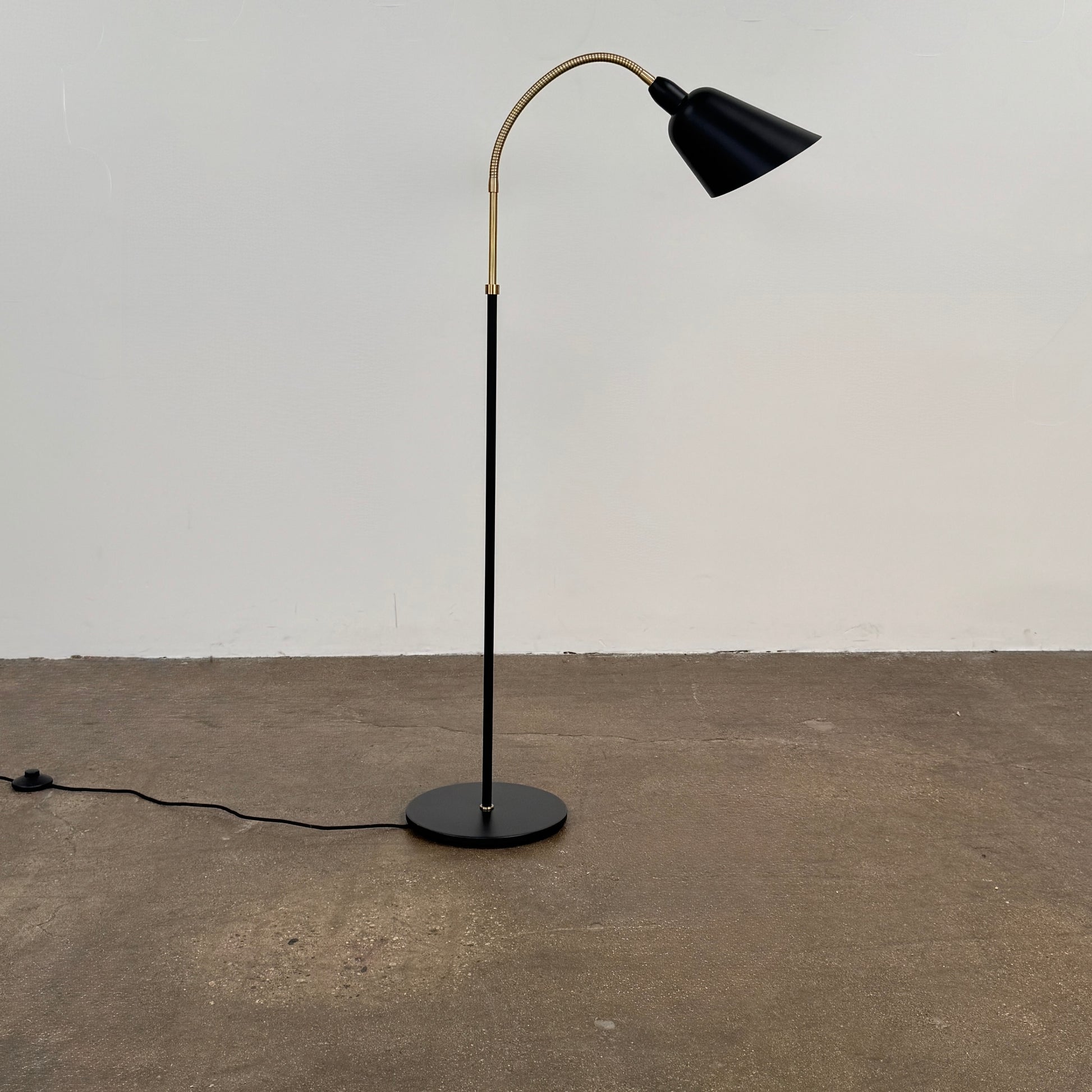 Close-up of a lamp label displaying model details—230V Max 60W E27, IP20—and manufacturer information above a black lamp socket, an elegant detail characteristic of the &Tradition Bellevue Floor Lamp AJ7 by &Tradition, a design that exemplifies Arne Jacobsen’s influential contribution to Scandinavian modernism.