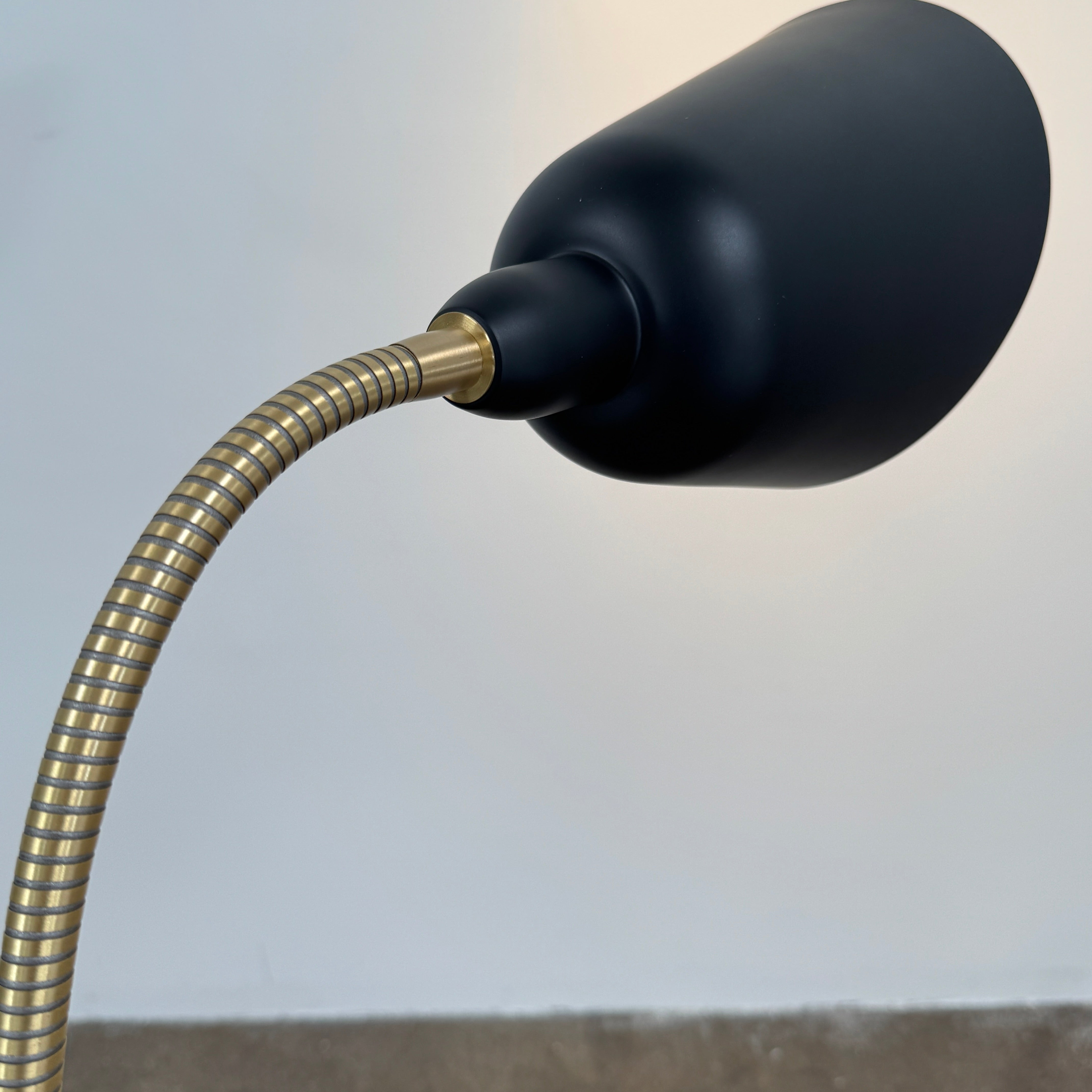 Close-up of a lamp label displaying model details—230V Max 60W E27, IP20—and manufacturer information above a black lamp socket, an elegant detail characteristic of the &Tradition Bellevue Floor Lamp AJ7 by &Tradition, a design that exemplifies Arne Jacobsen’s influential contribution to Scandinavian modernism.