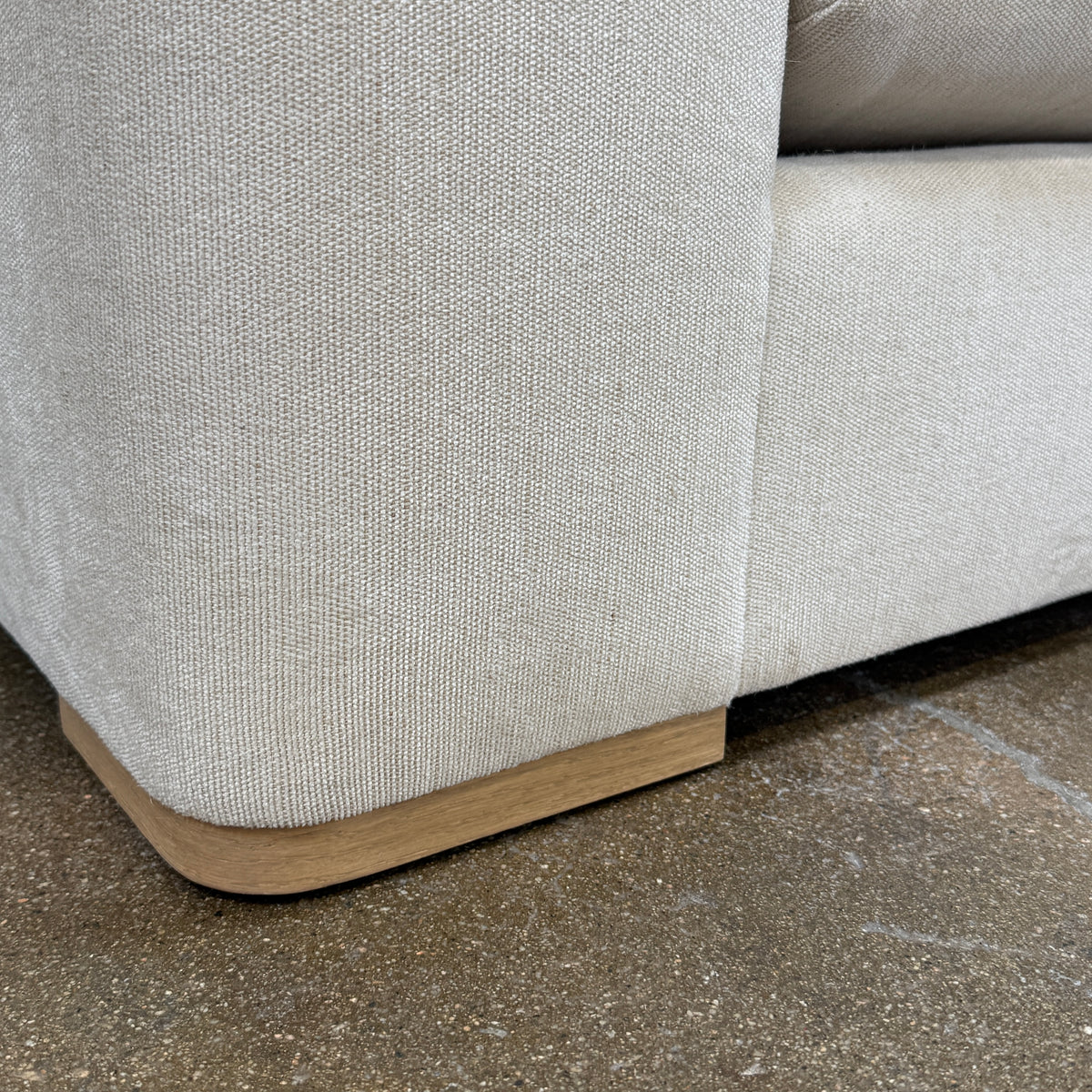 The Dmitriy & Co. Erato Sofa by Dimitriy & Co is a light gray three-seater featuring low arms and wooden feet, showcased against a plain white background—an elegant example of bespoke furnishings and couture upholstery.