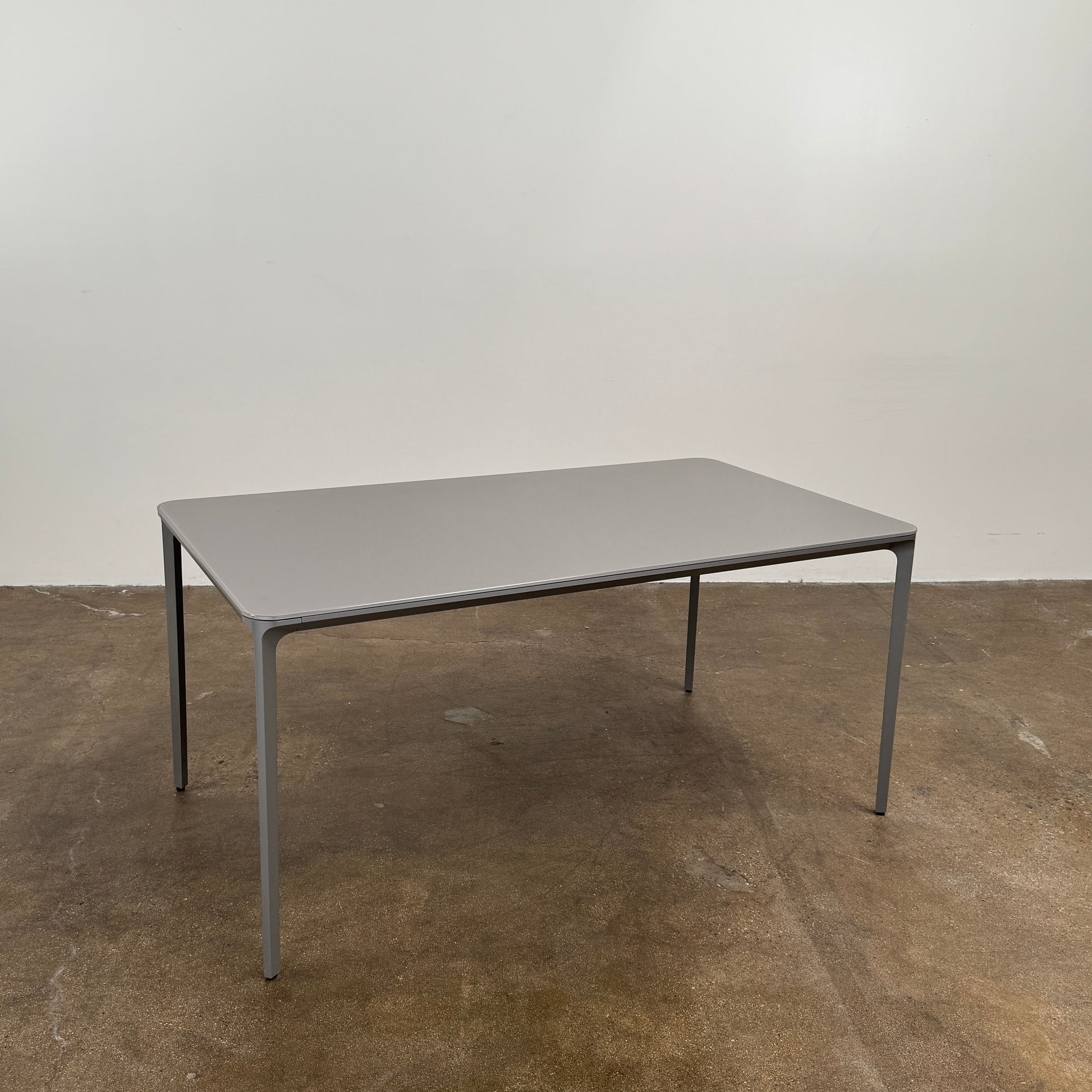 A minimalist rectangular Sovet Slim Extendable Dining Table in gray with four straight legs, designed by Sovet and photographed against a white background.