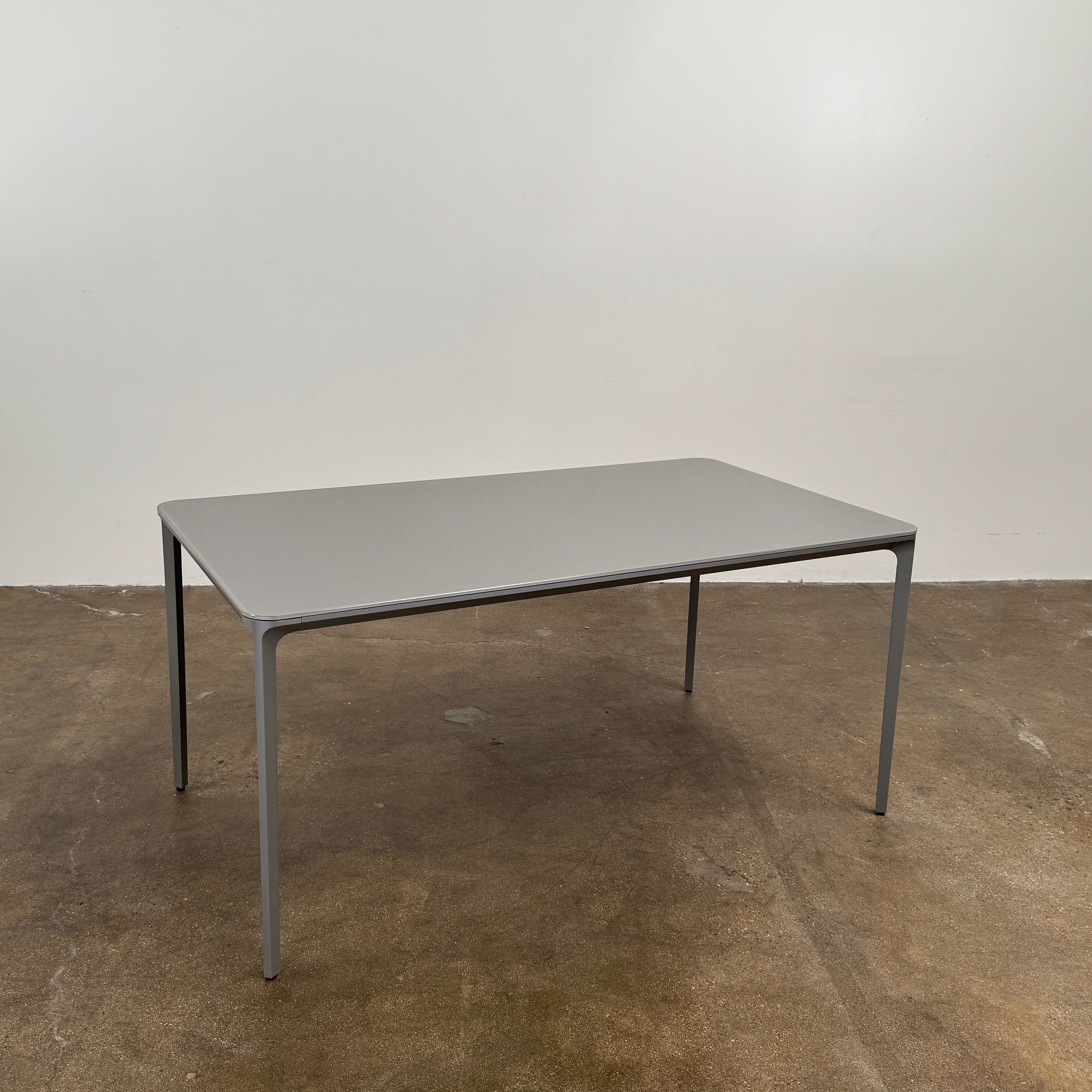 A minimalist rectangular Sovet Slim Extendable Dining Table in gray with four straight legs, designed by Sovet and photographed against a white background.