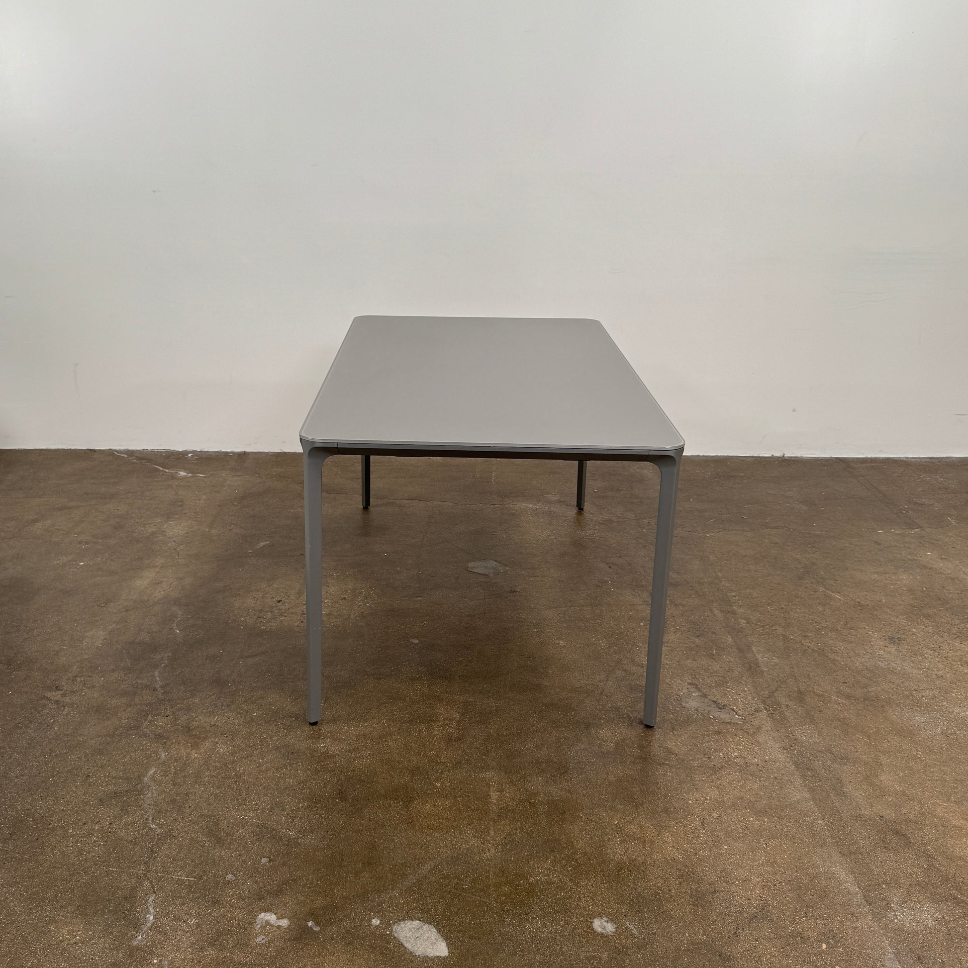 A minimalist rectangular Sovet Slim Extendable Dining Table in gray with four straight legs, designed by Sovet and photographed against a white background.
