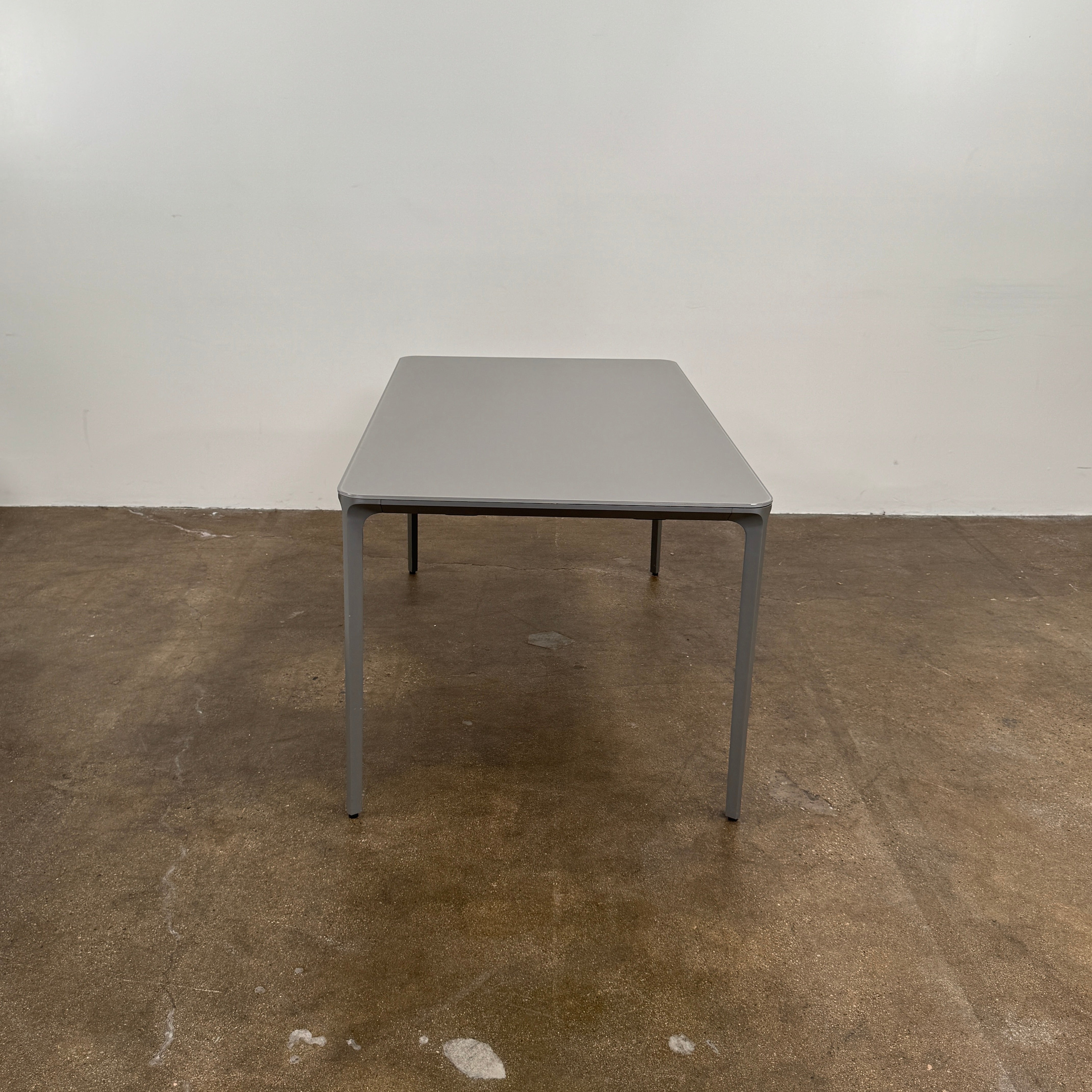 A minimalist rectangular Sovet Slim Extendable Dining Table in gray with four straight legs, designed by Sovet and photographed against a white background.