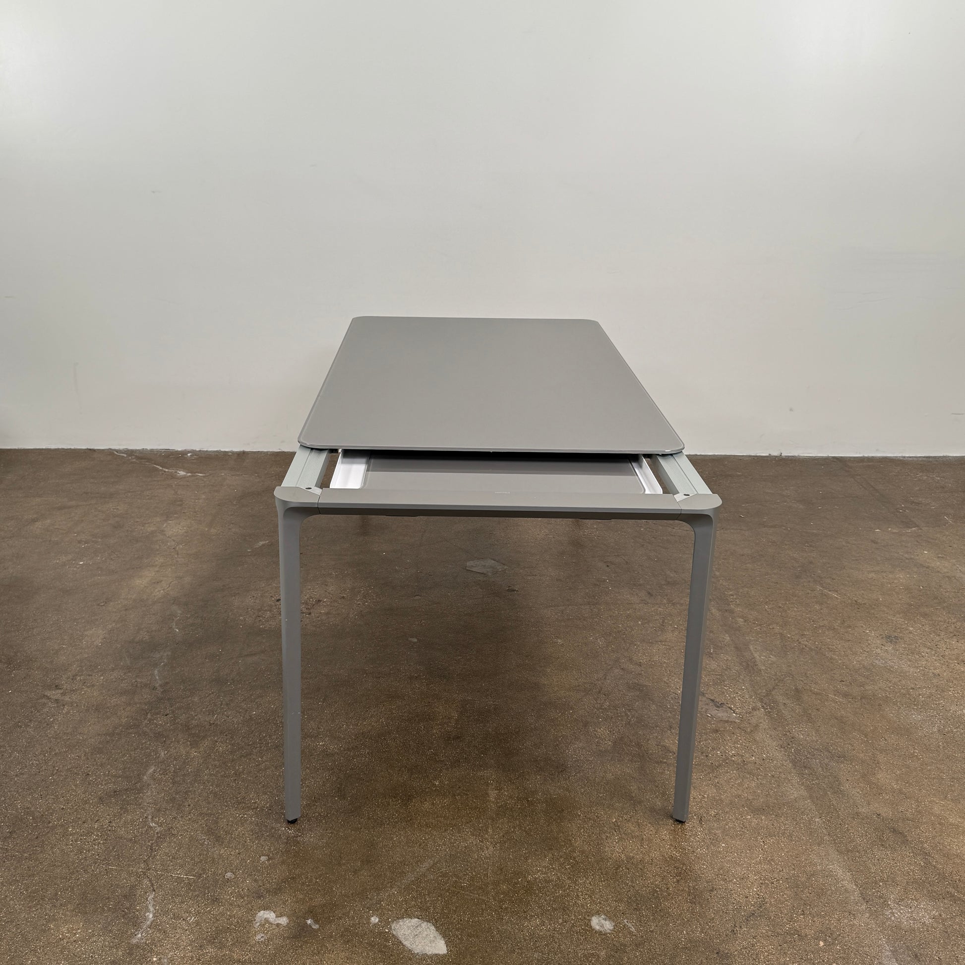 A minimalist rectangular Sovet Slim Extendable Dining Table in gray with four straight legs, designed by Sovet and photographed against a white background.