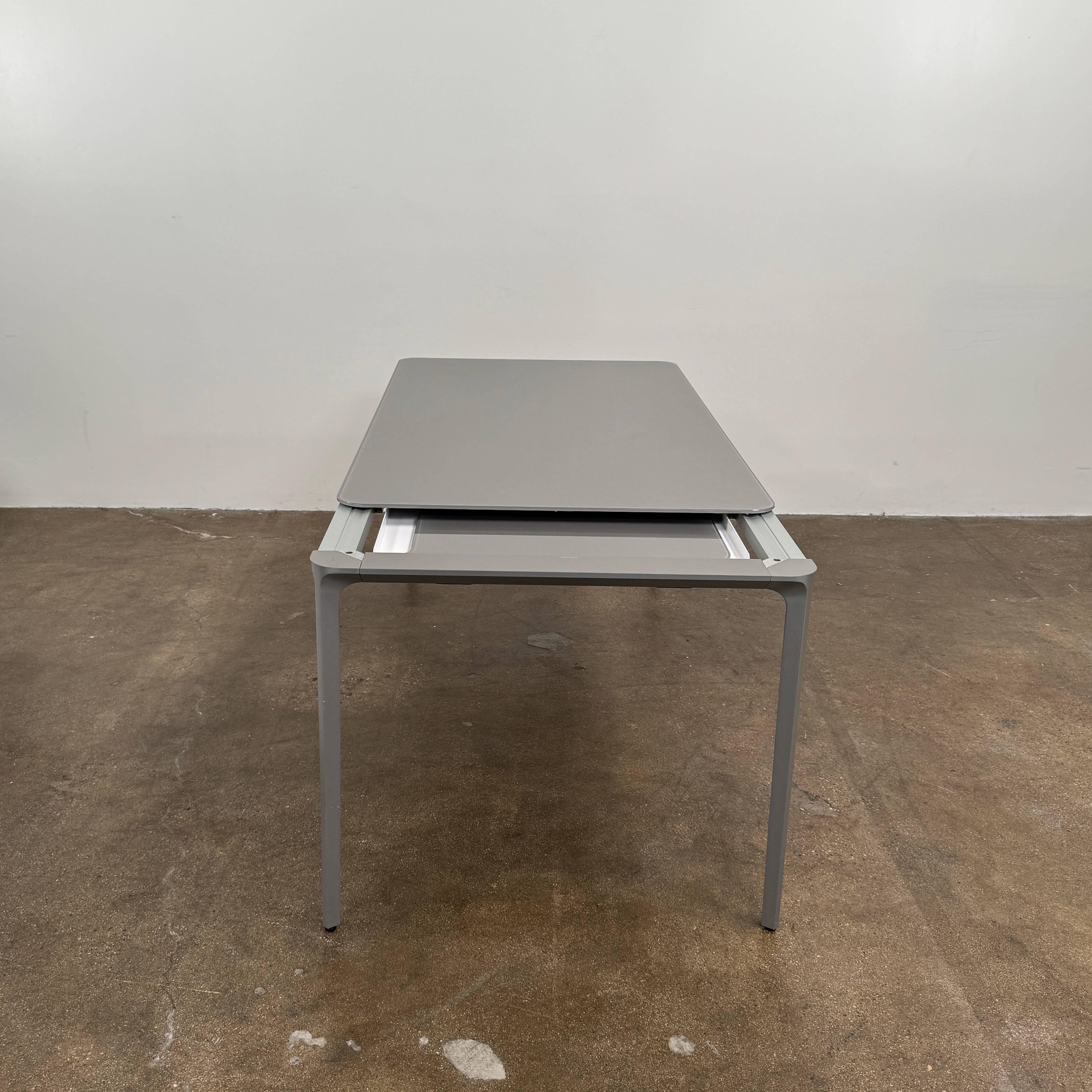 A minimalist rectangular Sovet Slim Extendable Dining Table in gray with four straight legs, designed by Sovet and photographed against a white background.