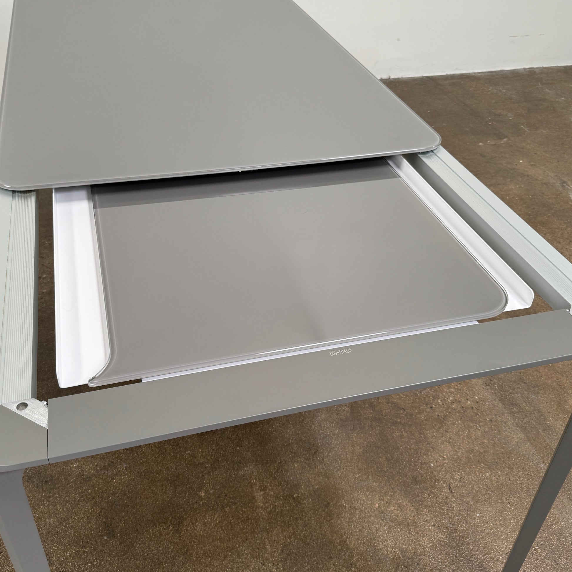 A minimalist rectangular Sovet Slim Extendable Dining Table in gray with four straight legs, designed by Sovet and photographed against a white background.