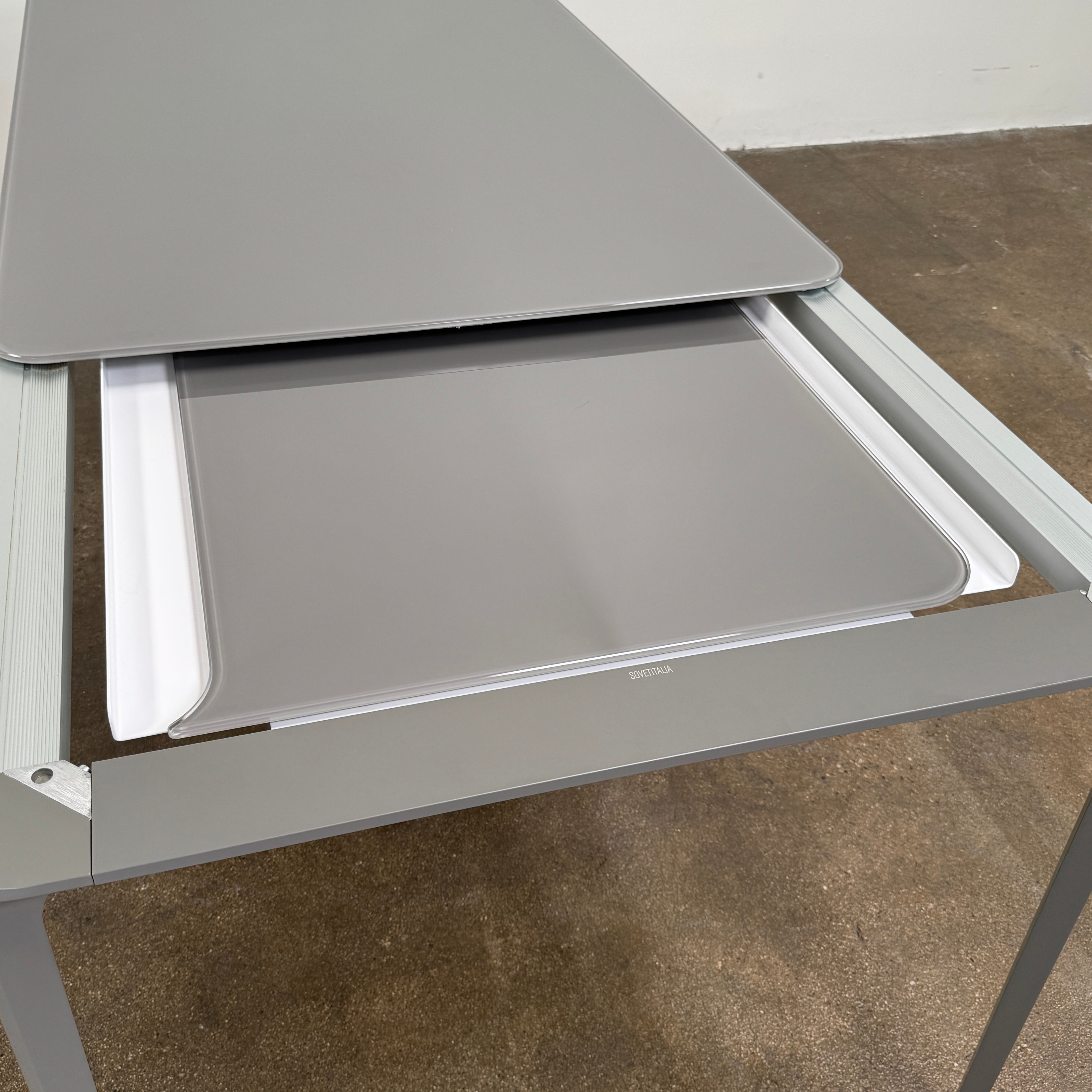 A minimalist rectangular Sovet Slim Extendable Dining Table in gray with four straight legs, designed by Sovet and photographed against a white background.
