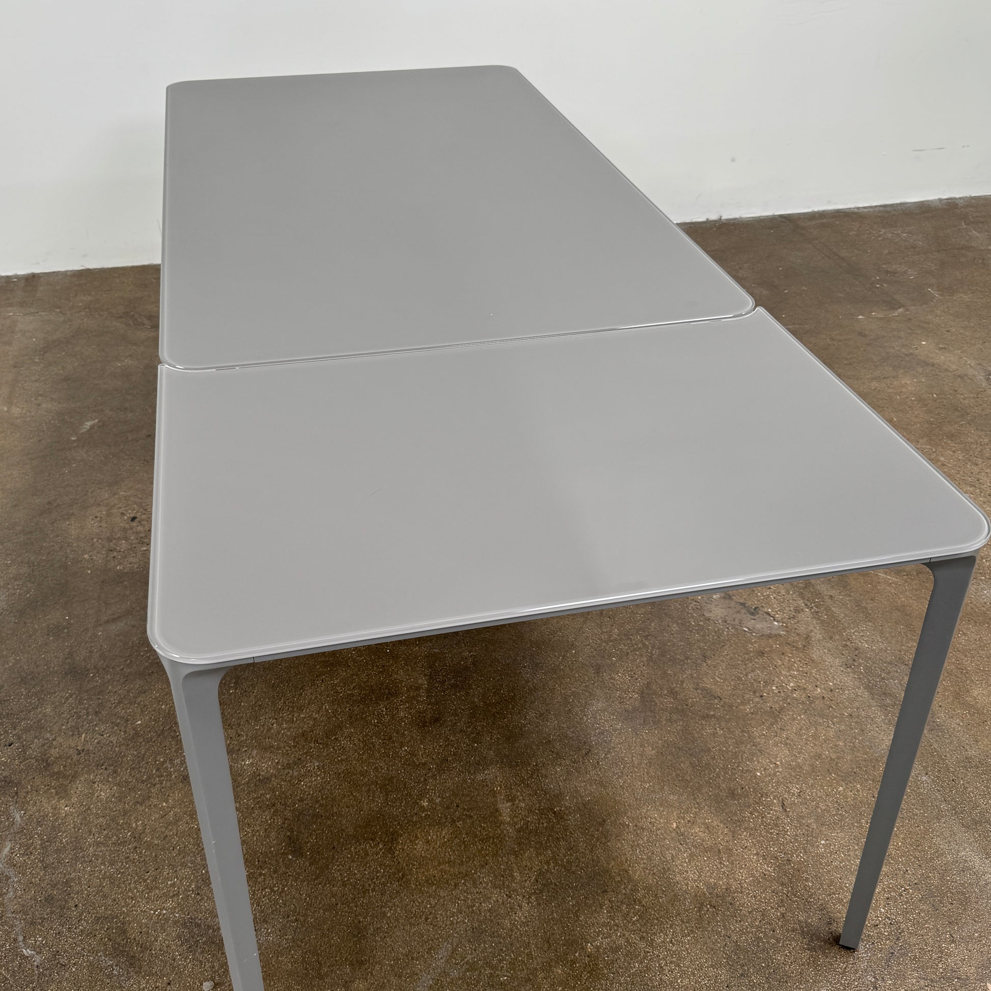 A minimalist rectangular Sovet Slim Extendable Dining Table in gray with four straight legs, designed by Sovet and photographed against a white background.