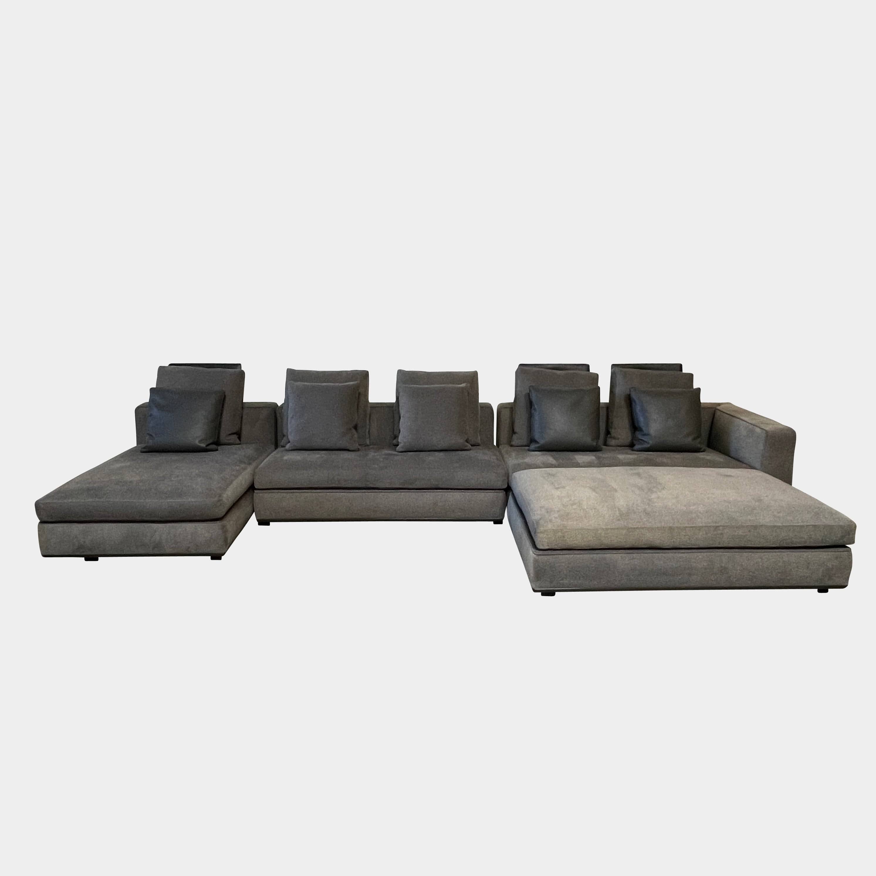 A Minotti Powell Sectional Sofa with black pillows from Minotti.