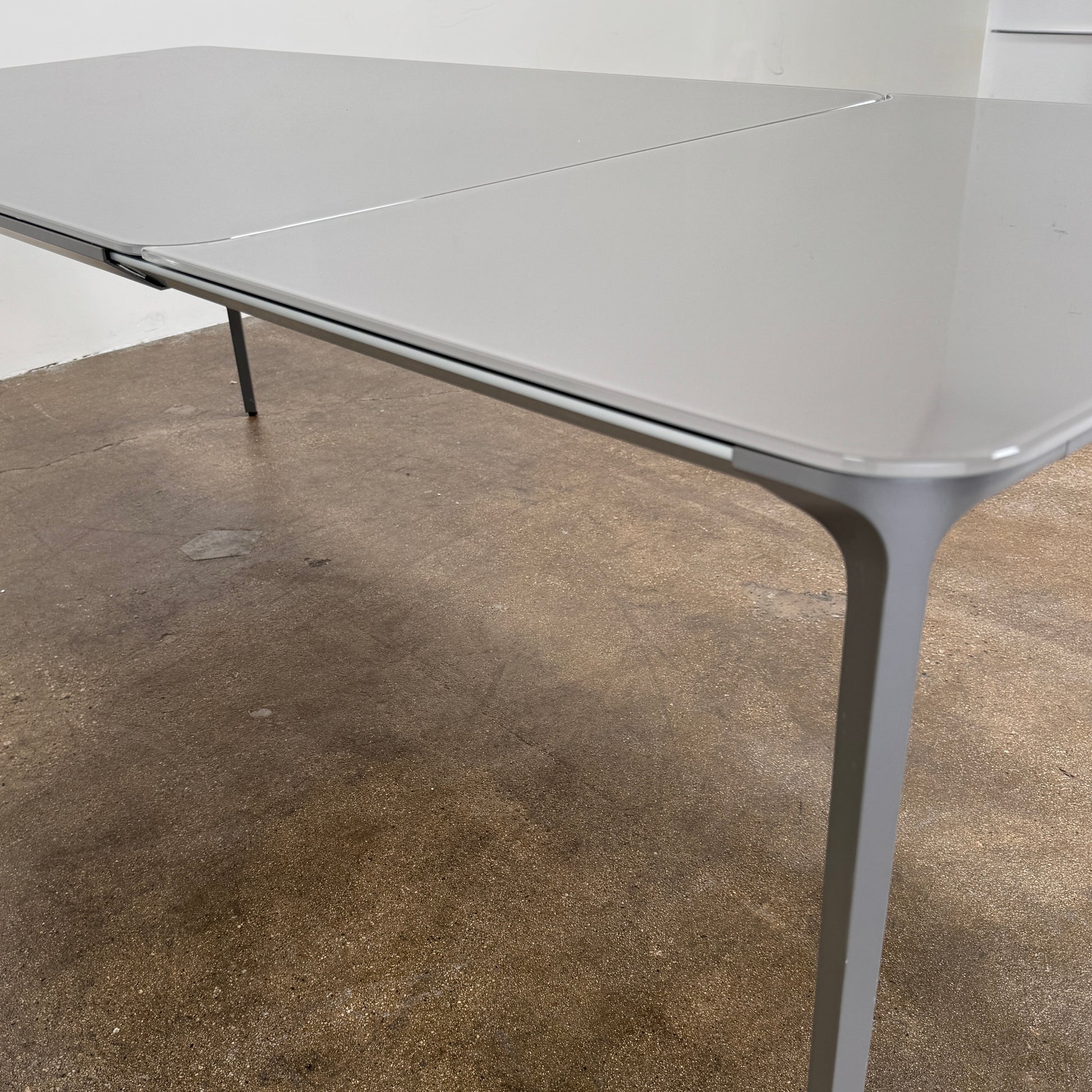 A minimalist rectangular Sovet Slim Extendable Dining Table in gray with four straight legs, designed by Sovet and photographed against a white background.