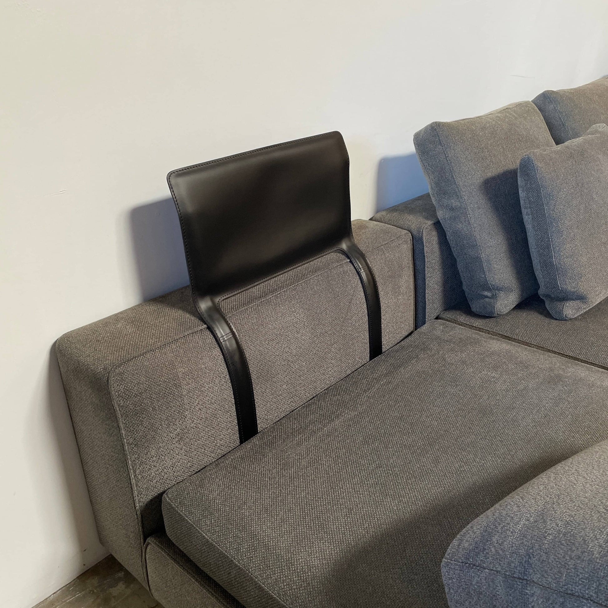 A Minotti Powell Sectional Sofa with black pillows from Minotti.