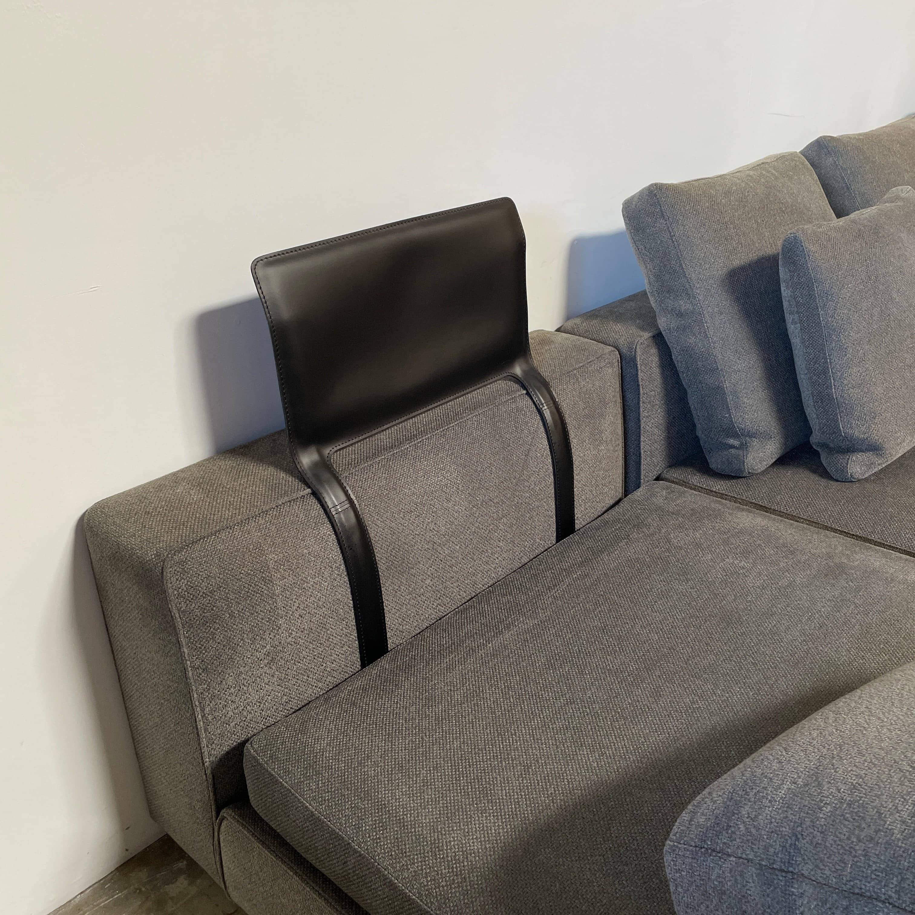A Minotti Powell Sectional Sofa with black pillows from Minotti.