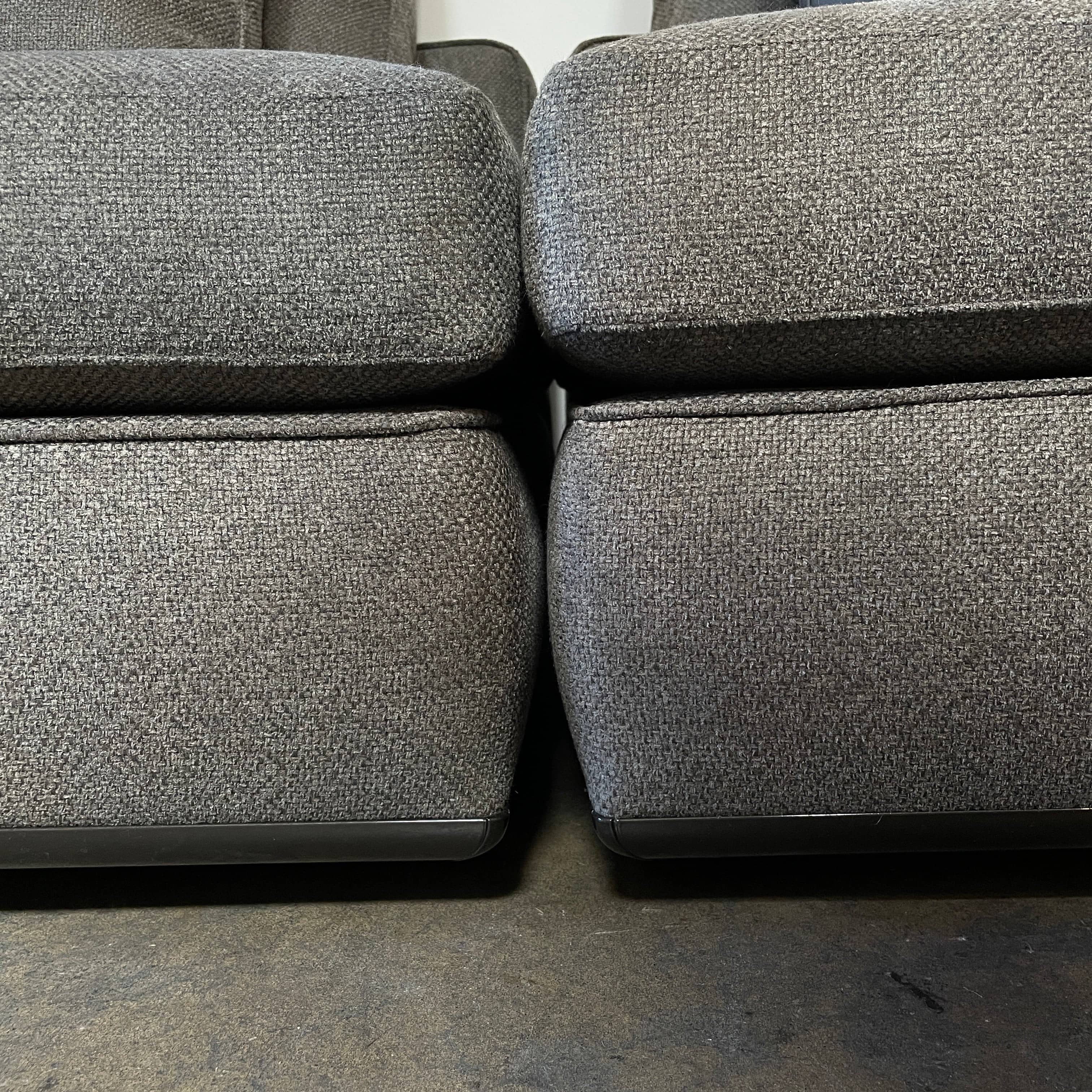 A Minotti Powell Sectional Sofa with black pillows from Minotti.