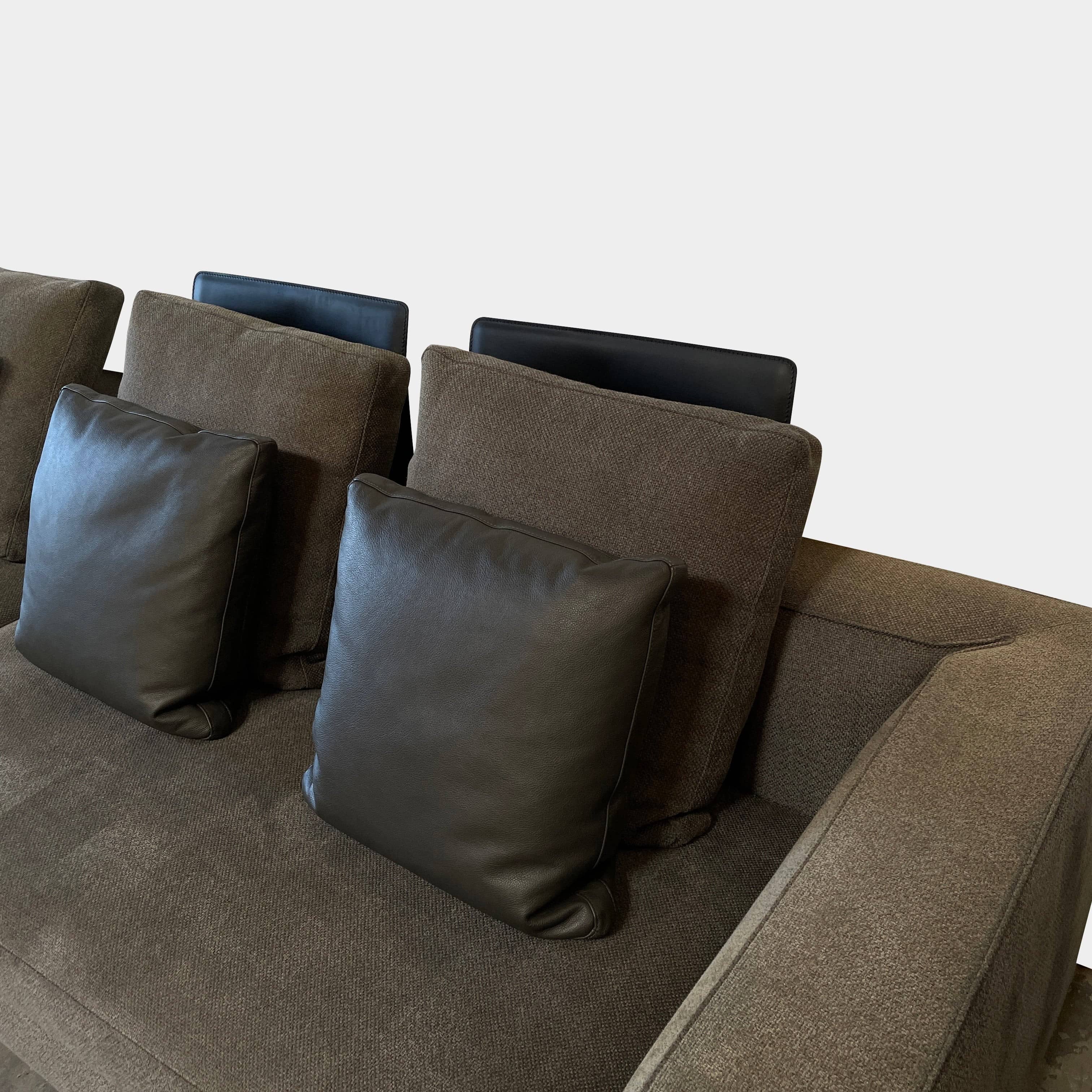 A Minotti Powell Sectional Sofa with black pillows from Minotti.