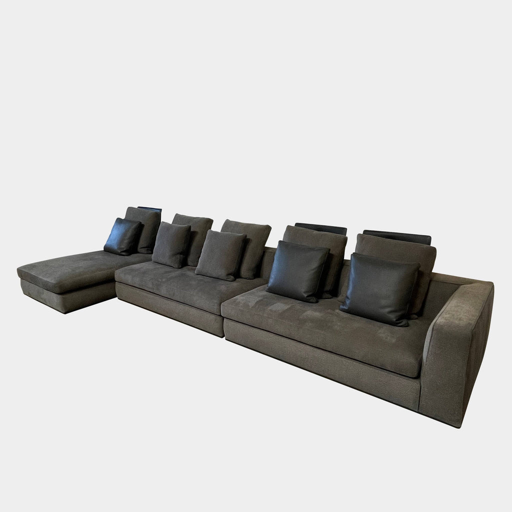 A Minotti Powell Sectional Sofa with black pillows from Minotti.