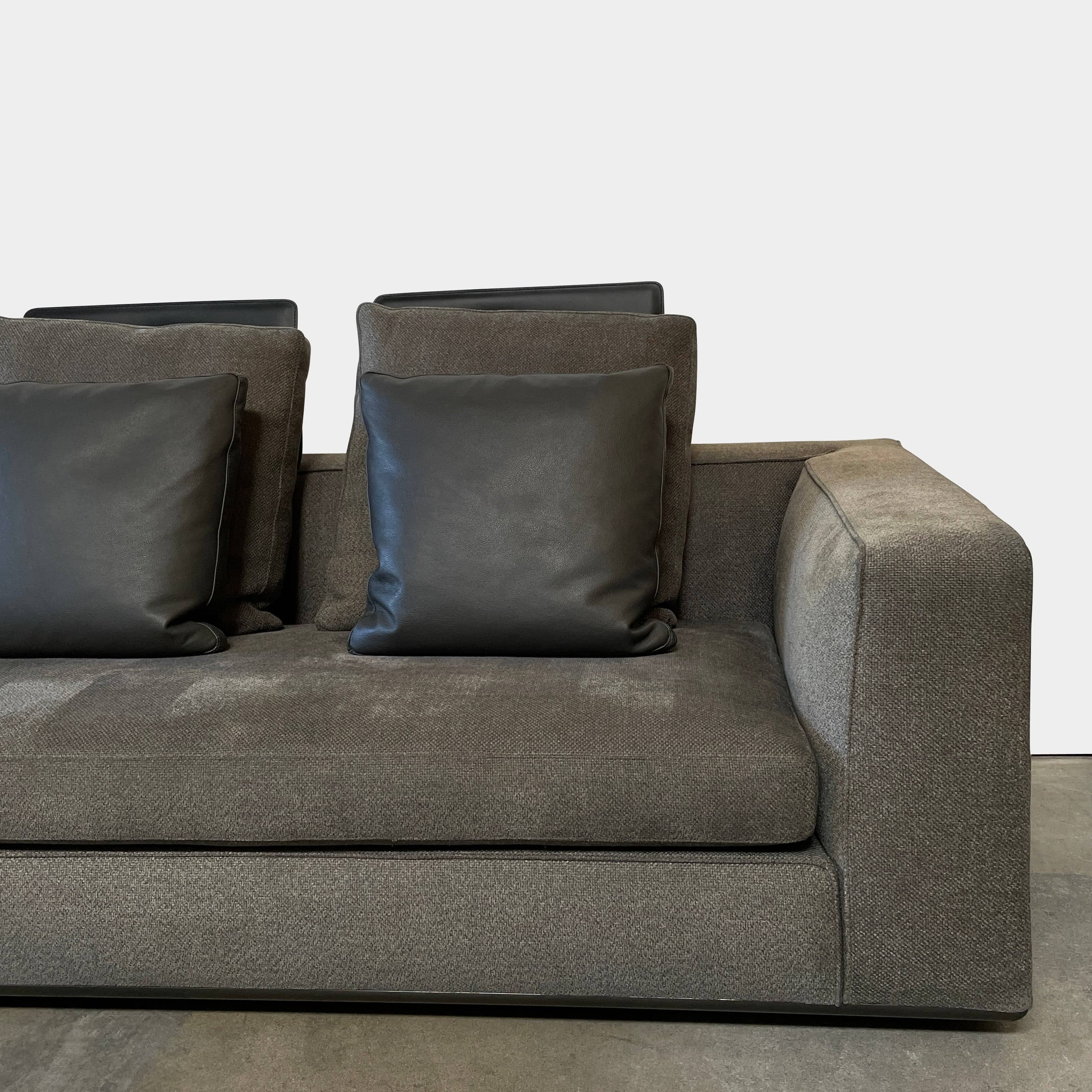 A Minotti Powell Sectional Sofa with black pillows from Minotti.
