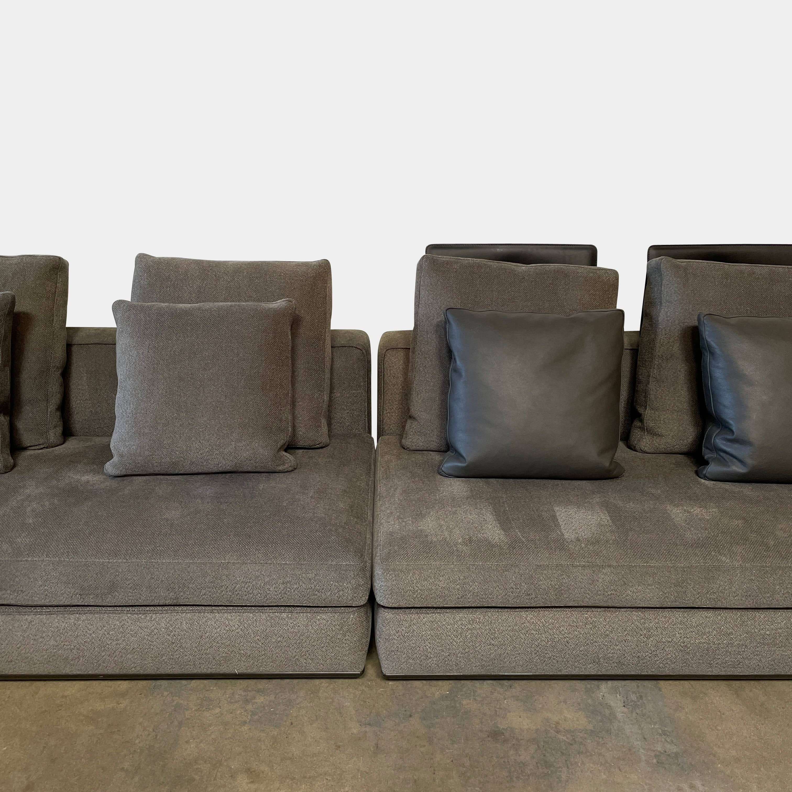 A Minotti Powell Sectional Sofa with black pillows from Minotti.