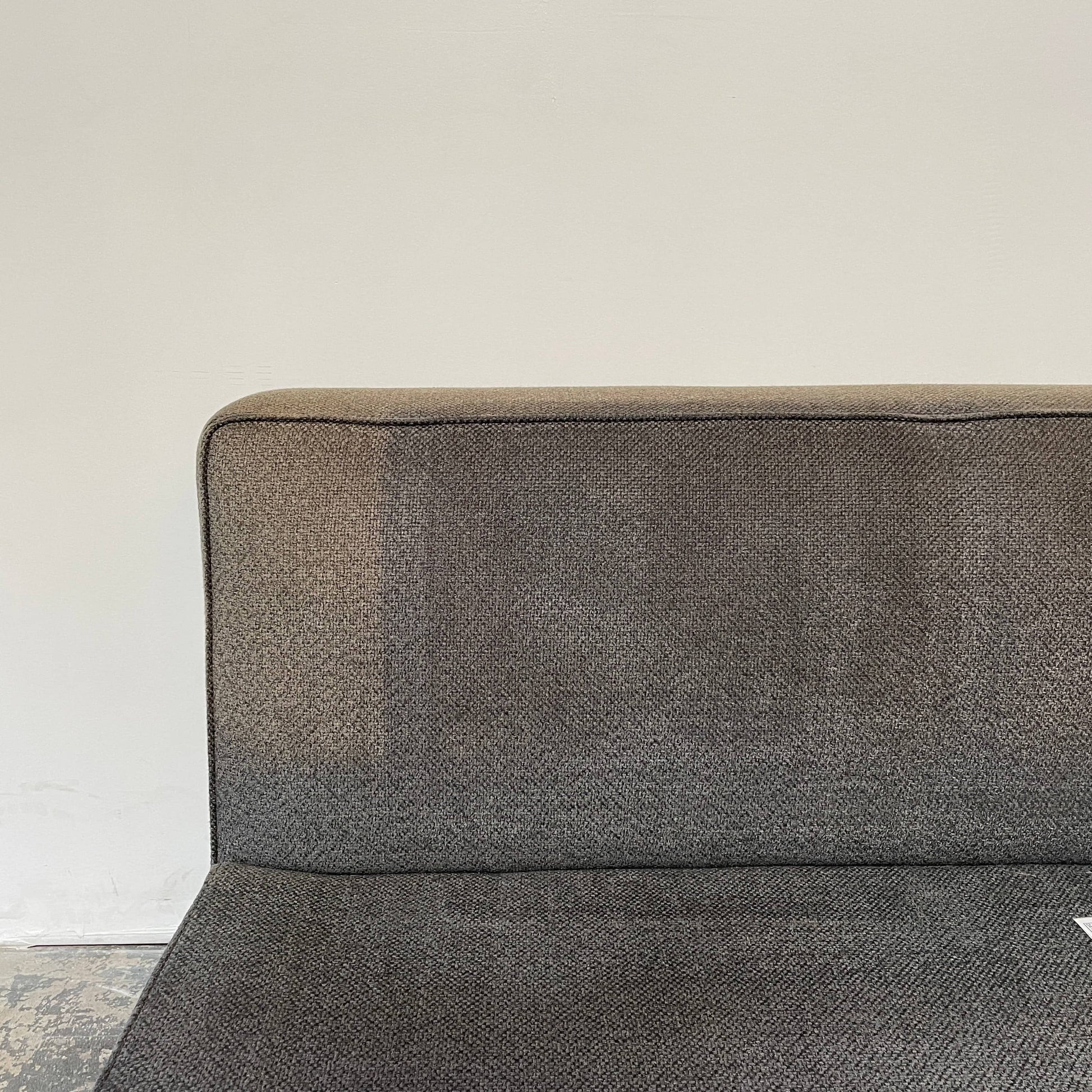 A Minotti Powell Sectional Sofa with black pillows from Minotti.