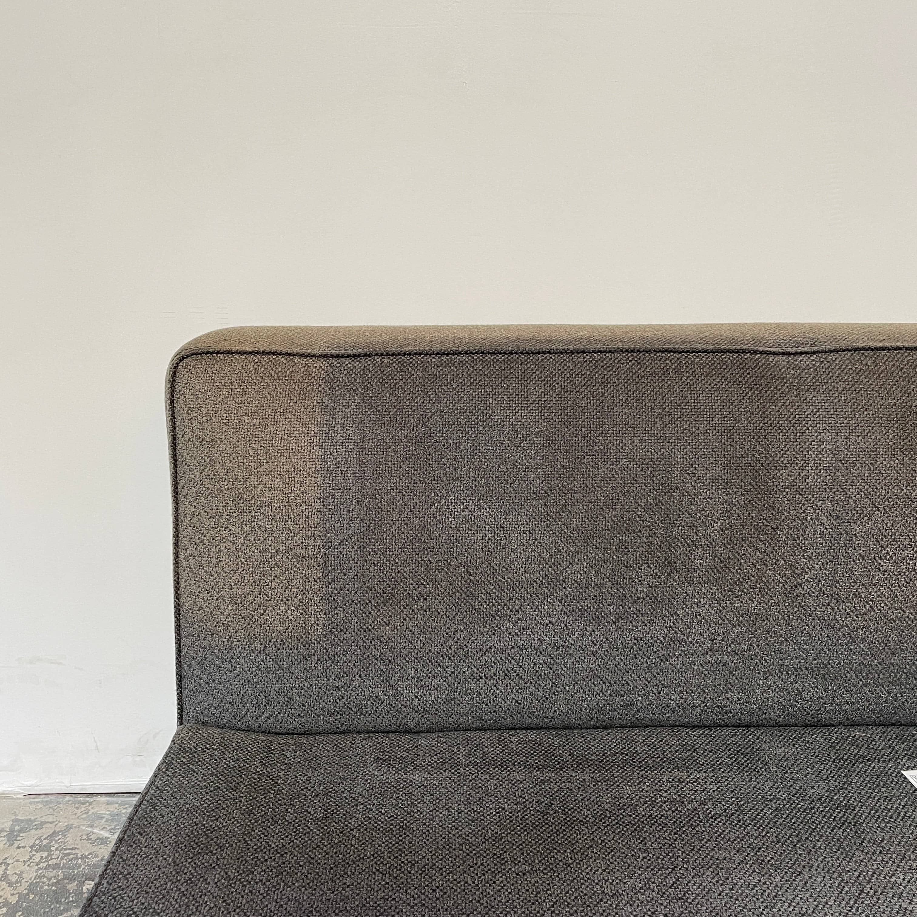 A Minotti Powell Sectional Sofa with black pillows from Minotti.