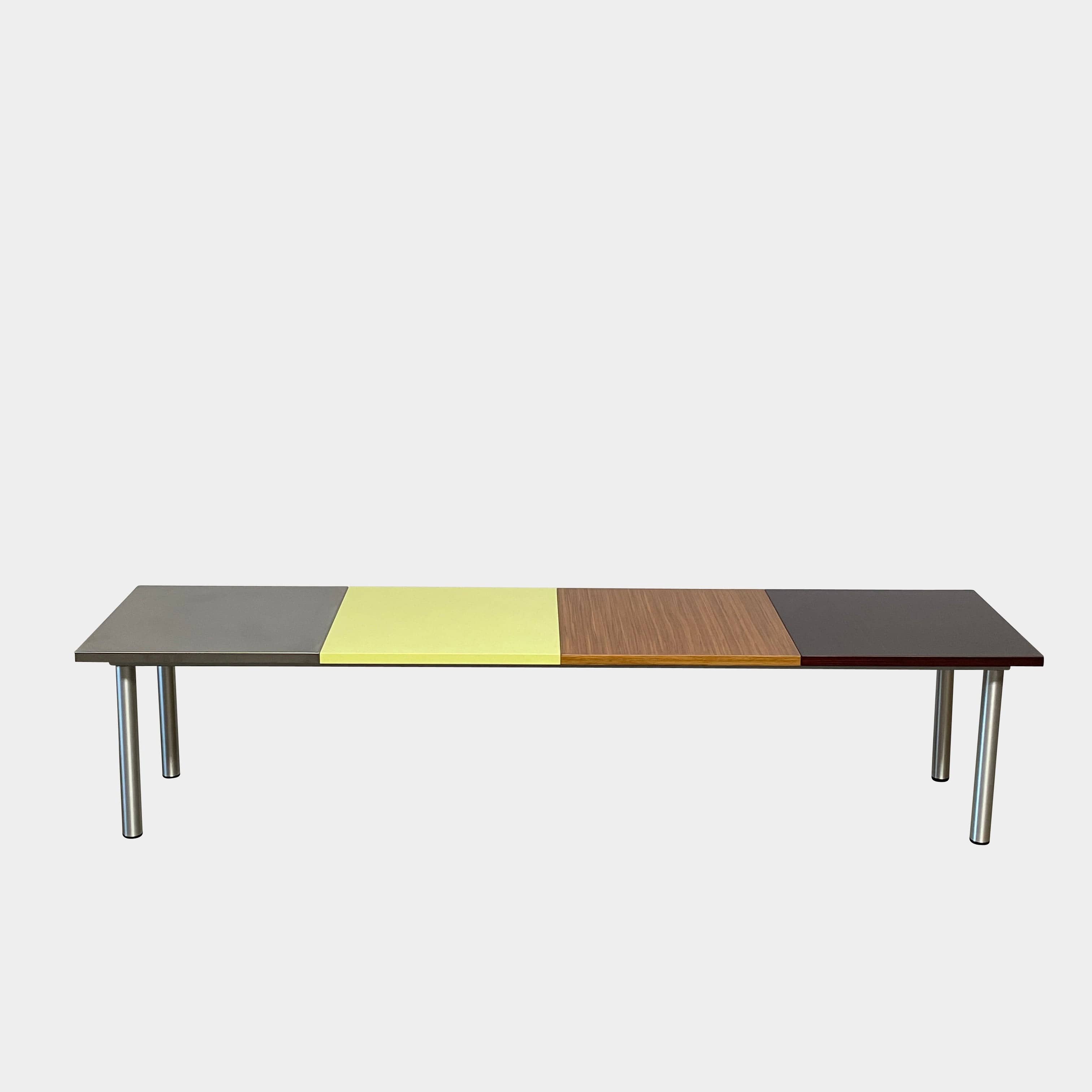 The Mazzei Multi-Panel Table by Mazzei is a contemporary design featuring a bench with a vibrant yellow, green, and blue top that adds functionality to any space.