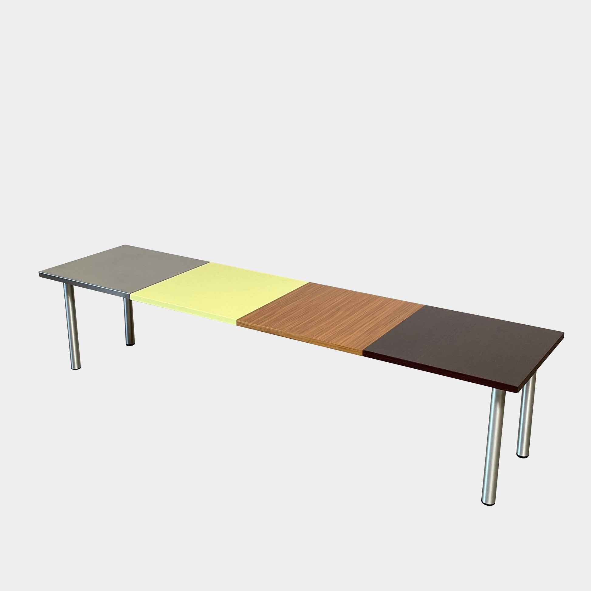 The Mazzei Multi-Panel Table by Mazzei is a contemporary design featuring a bench with a vibrant yellow, green, and blue top that adds functionality to any space.