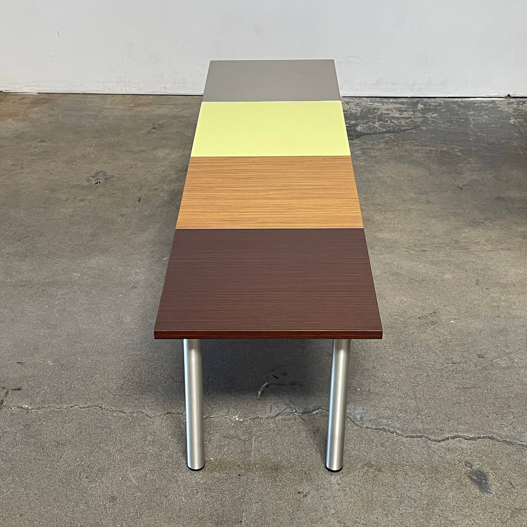 The Mazzei Multi-Panel Table by Mazzei is a contemporary design featuring a bench with a vibrant yellow, green, and blue top that adds functionality to any space.