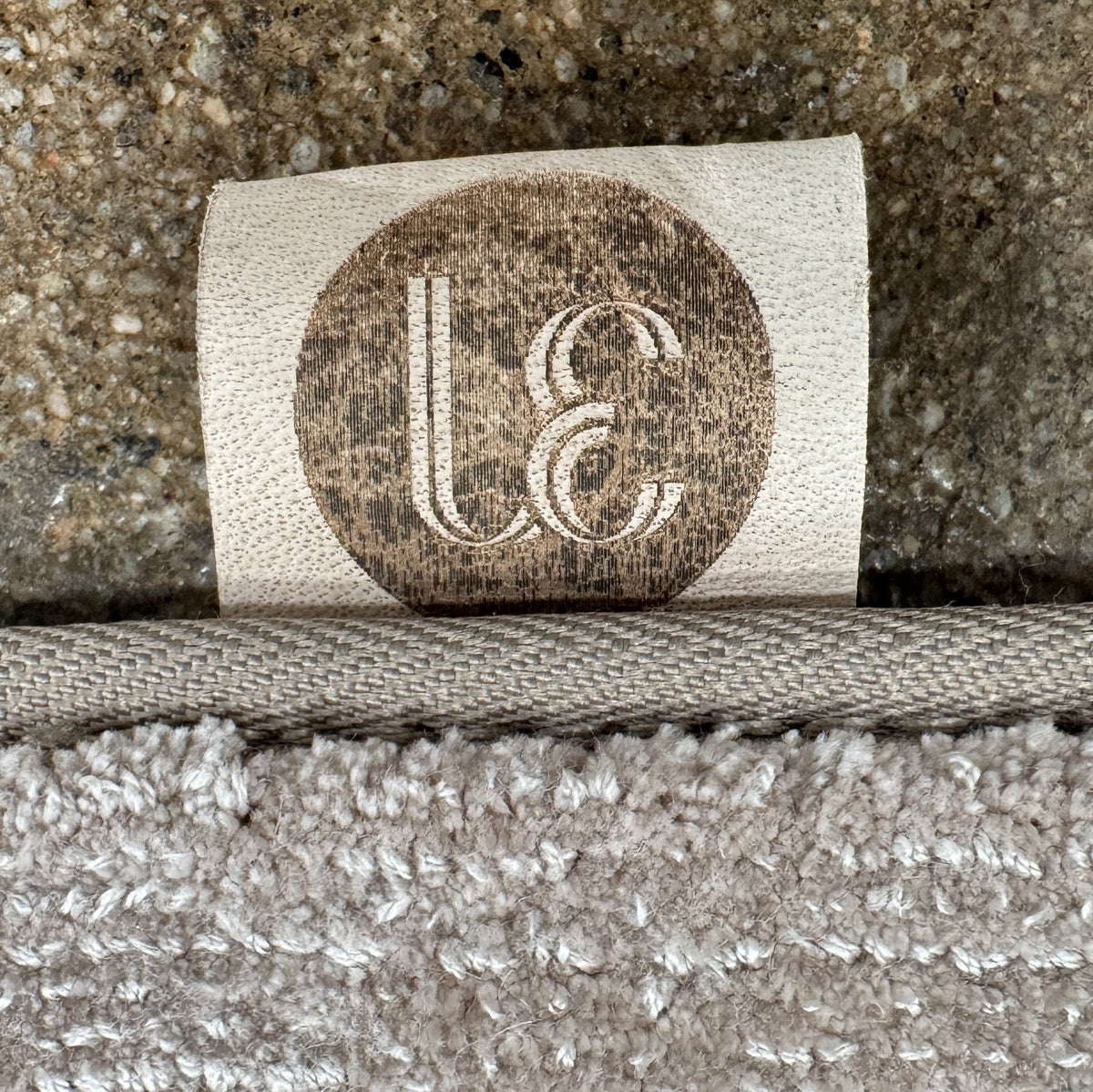 A close-up view of the Limited Edition 10 x 13.5′ Silk Rug, a rectangular, light gray area rug featuring a subtle textured pattern, crafted by the renowned Belgian brand Limited Edition. The luxurious silk rug is photographed against a plain white background.