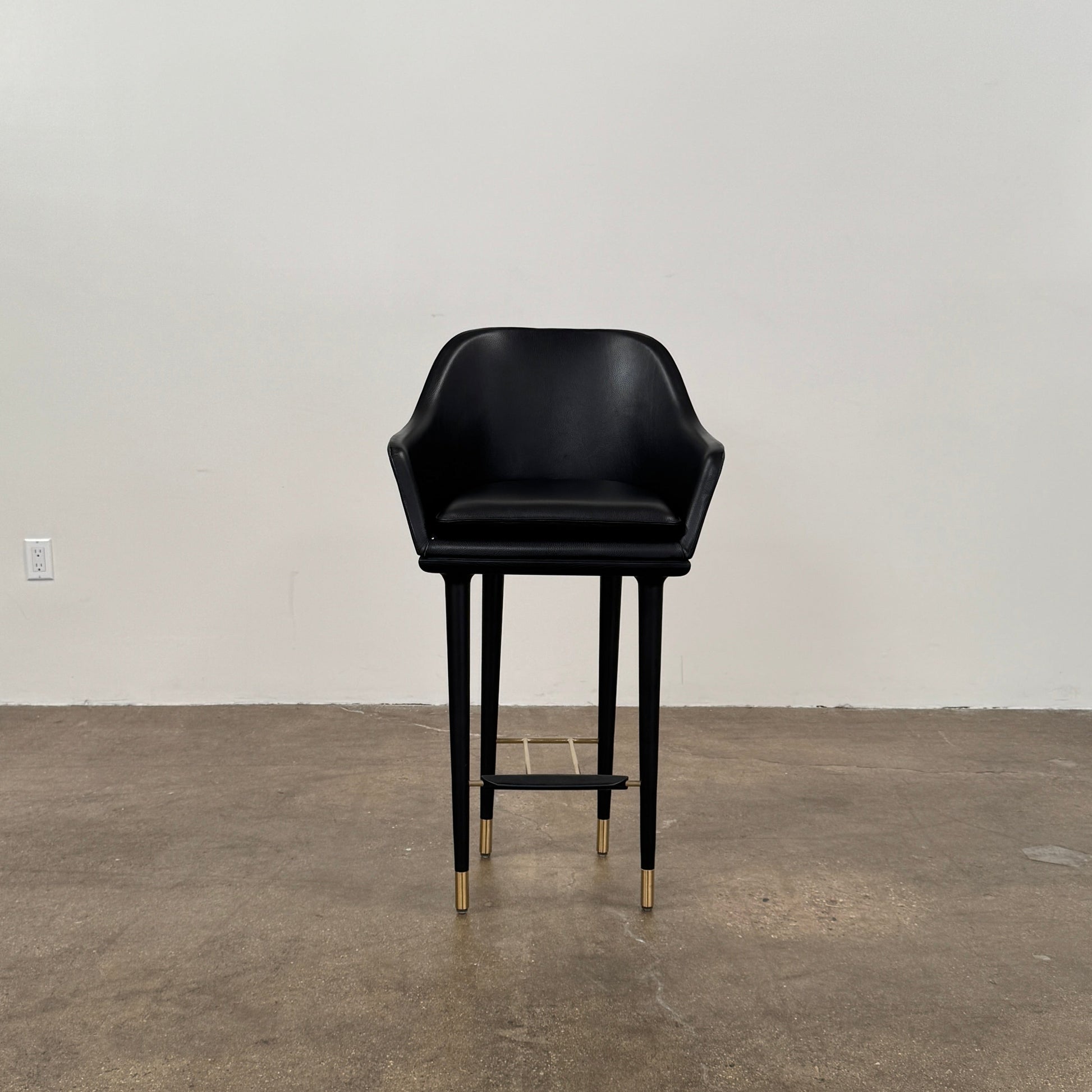 A set of three Stellar Works Lunar Bar Chairs by Steller Works, featuring black leather upholstery, armrests, and gold accents, is arranged in a row against a plain white background.