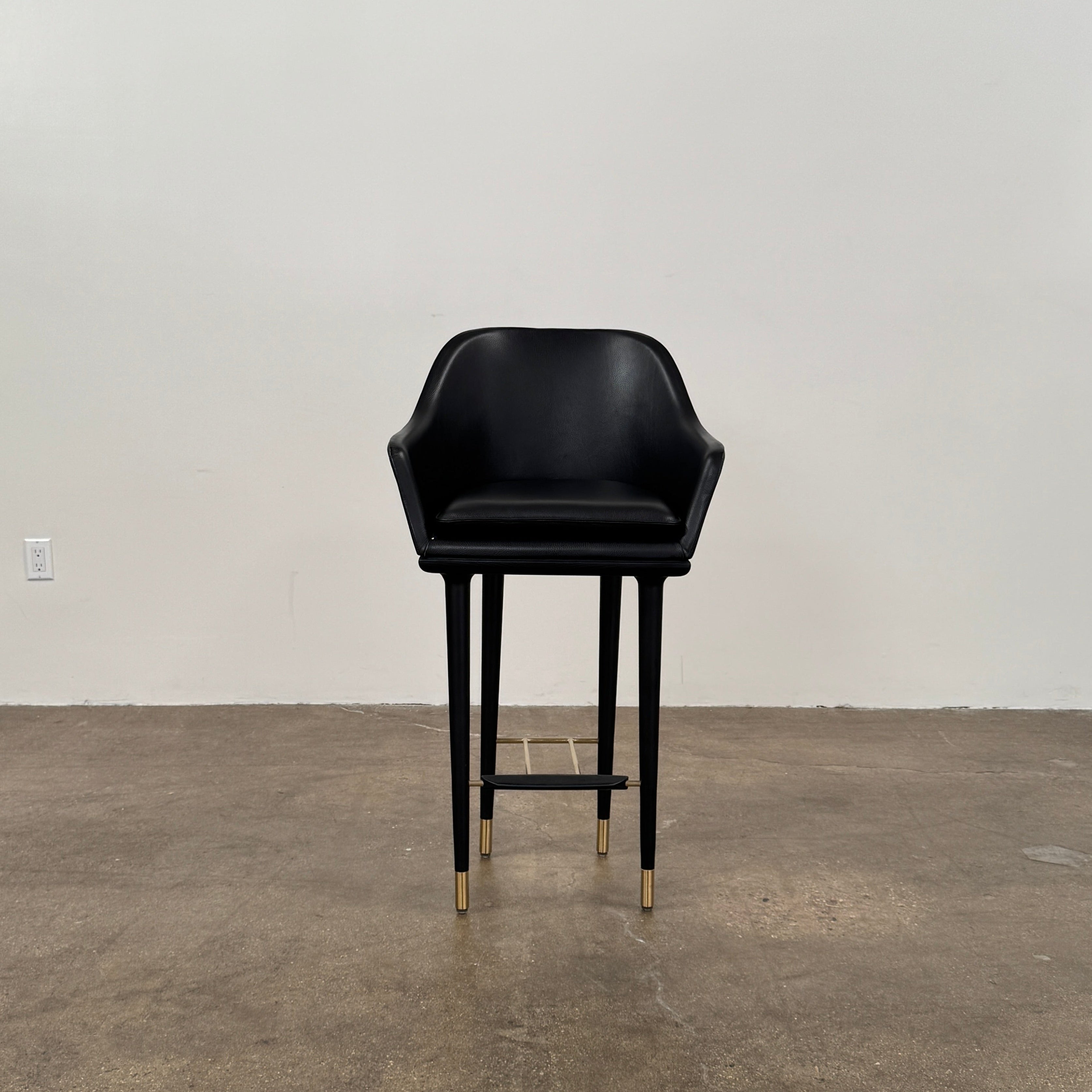 A set of three Stellar Works Lunar Bar Chairs by Steller Works, featuring black leather upholstery, armrests, and gold accents, is arranged in a row against a plain white background.