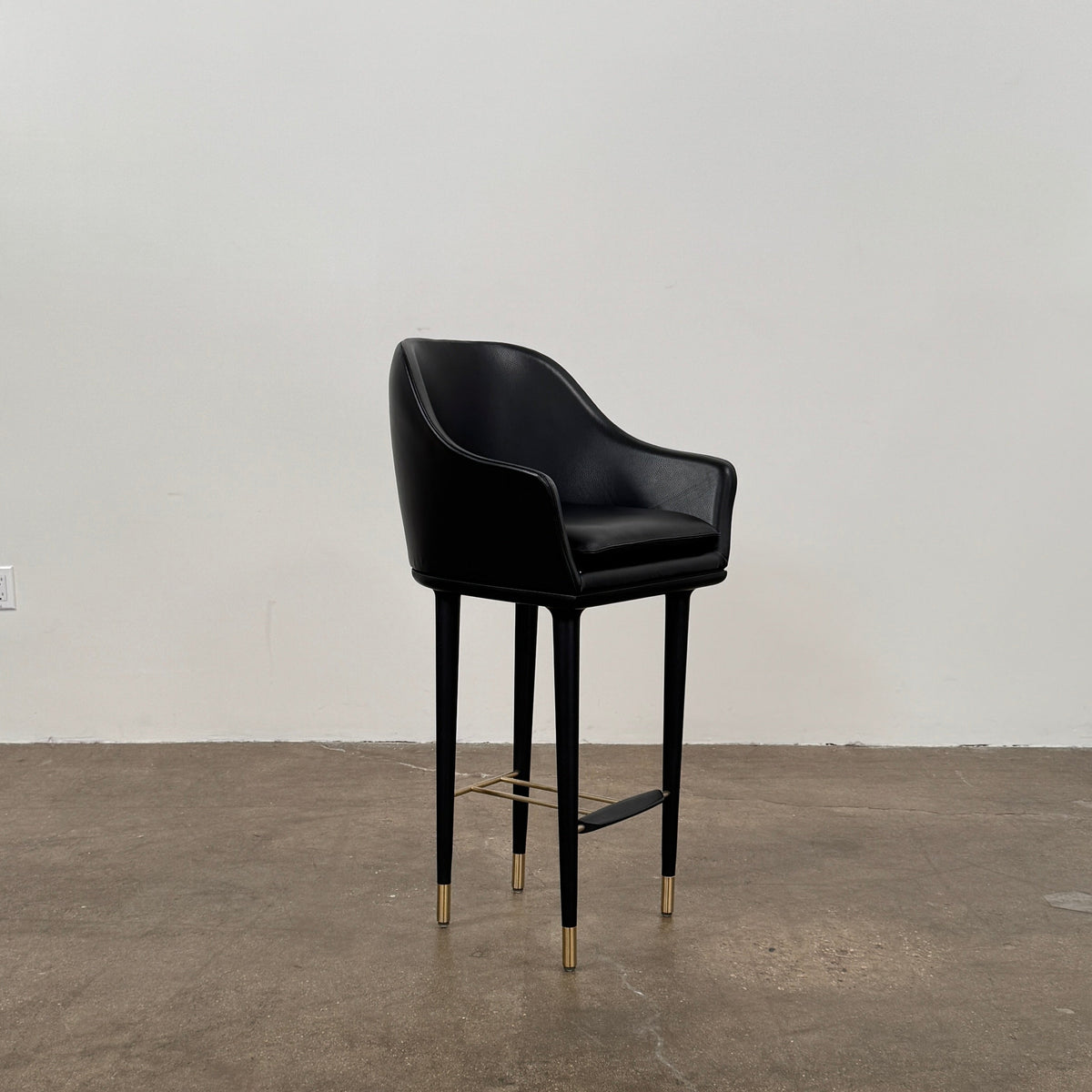 A set of three Stellar Works Lunar Bar Chairs by Steller Works, featuring black leather upholstery, armrests, and gold accents, is arranged in a row against a plain white background.