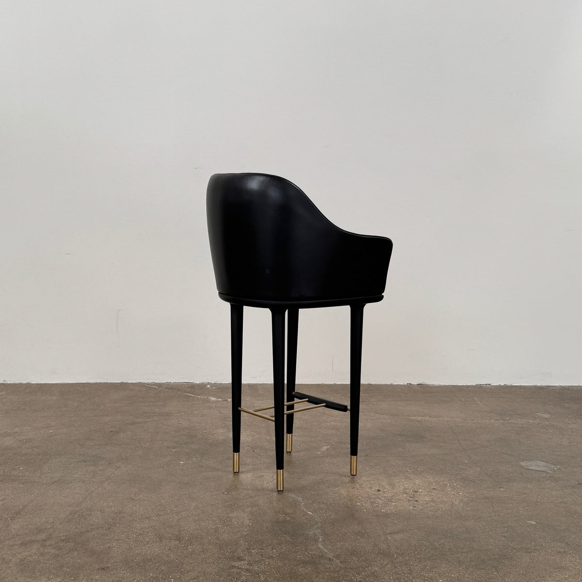A set of three Stellar Works Lunar Bar Chairs by Steller Works, featuring black leather upholstery, armrests, and gold accents, is arranged in a row against a plain white background.