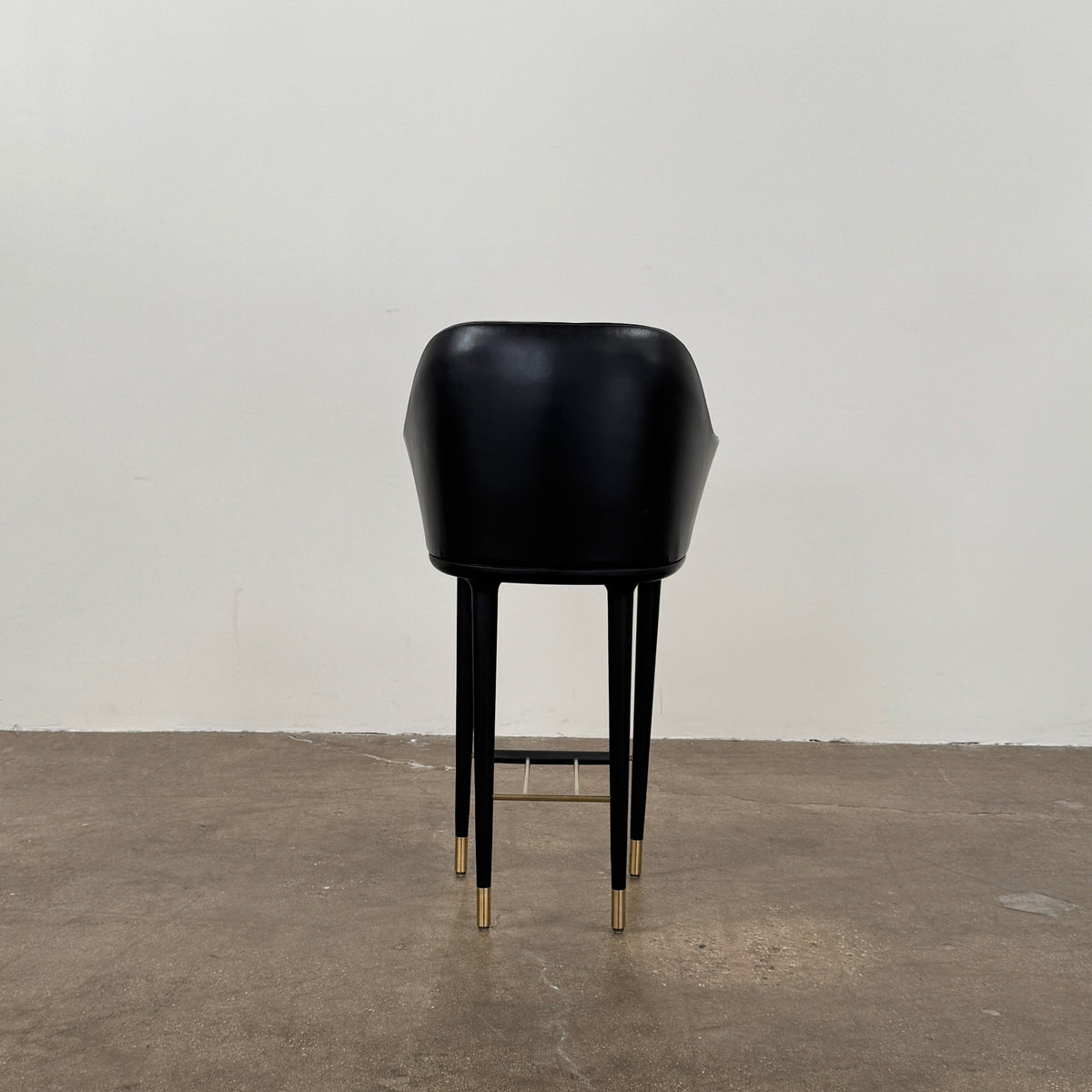 A set of three Stellar Works Lunar Bar Chairs by Steller Works, featuring black leather upholstery, armrests, and gold accents, is arranged in a row against a plain white background.