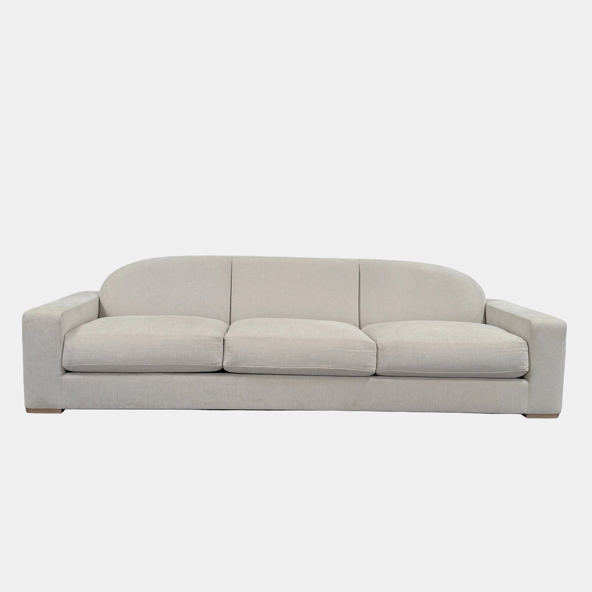 The Dmitriy & Co. Erato Sofa by Dimitriy & Co is a light gray three-seater featuring low arms and wooden feet, showcased against a plain white background—an elegant example of bespoke furnishings and couture upholstery.