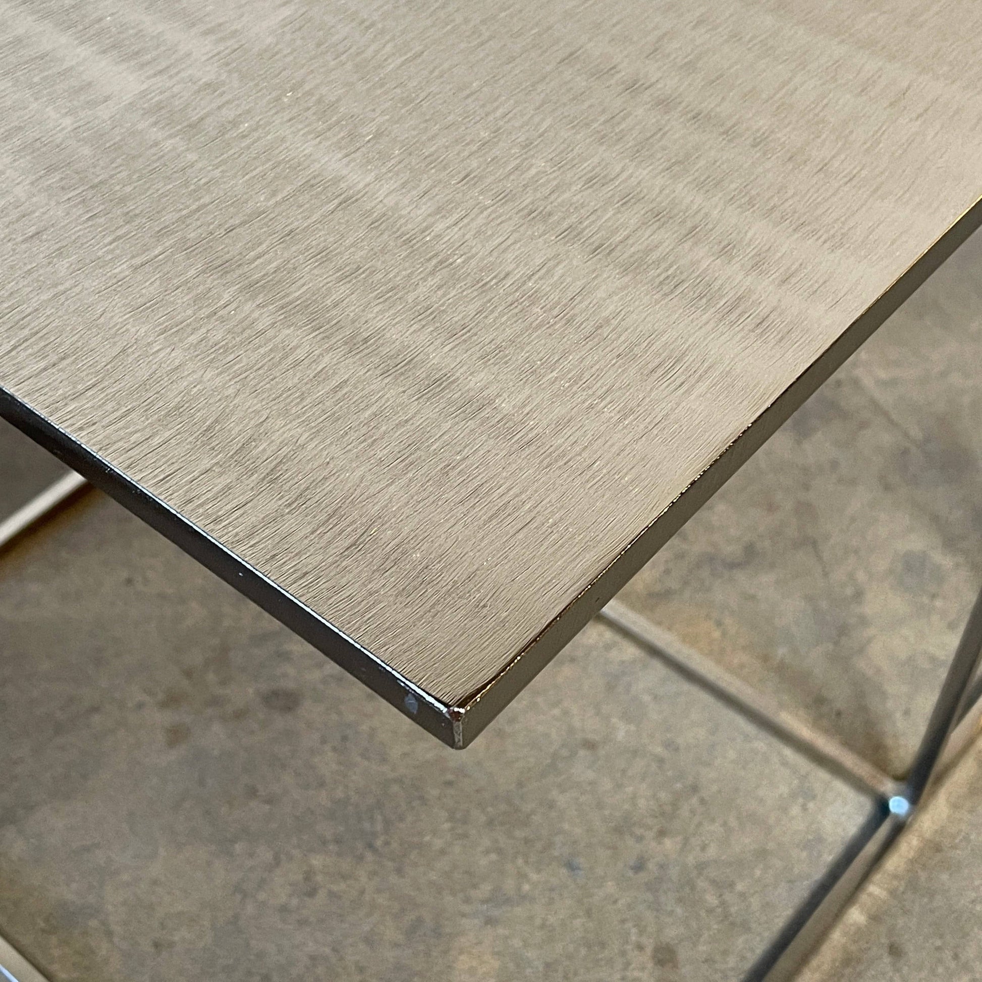 The Minotti Leger Side Table, by Minotti, features a metallic accent with its metal frame, creating a clean and minimal design against a white background.