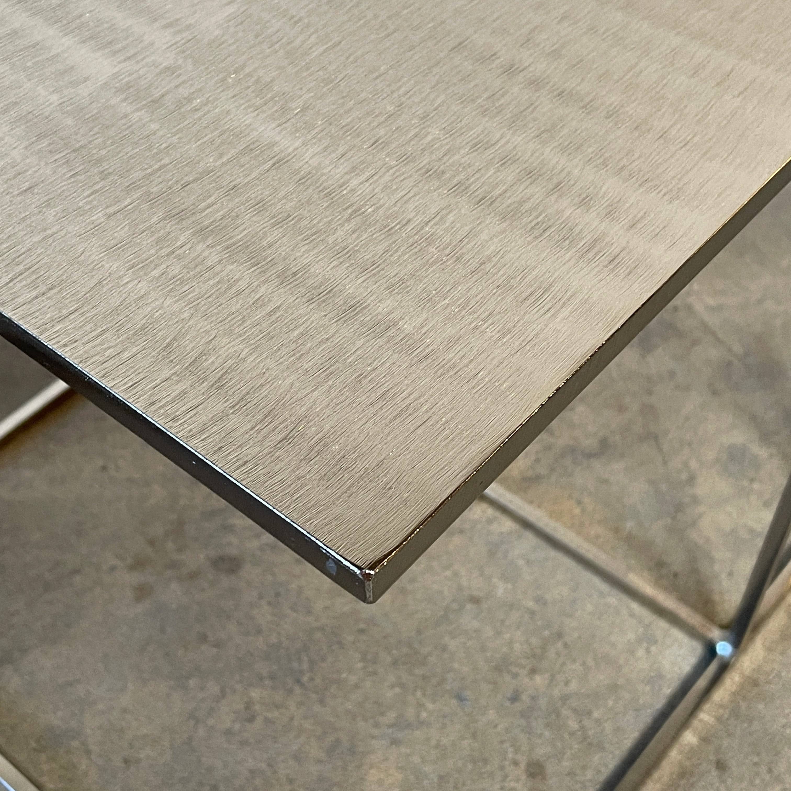 The Minotti Leger Side Table, by Minotti, features a metallic accent with its metal frame, creating a clean and minimal design against a white background.