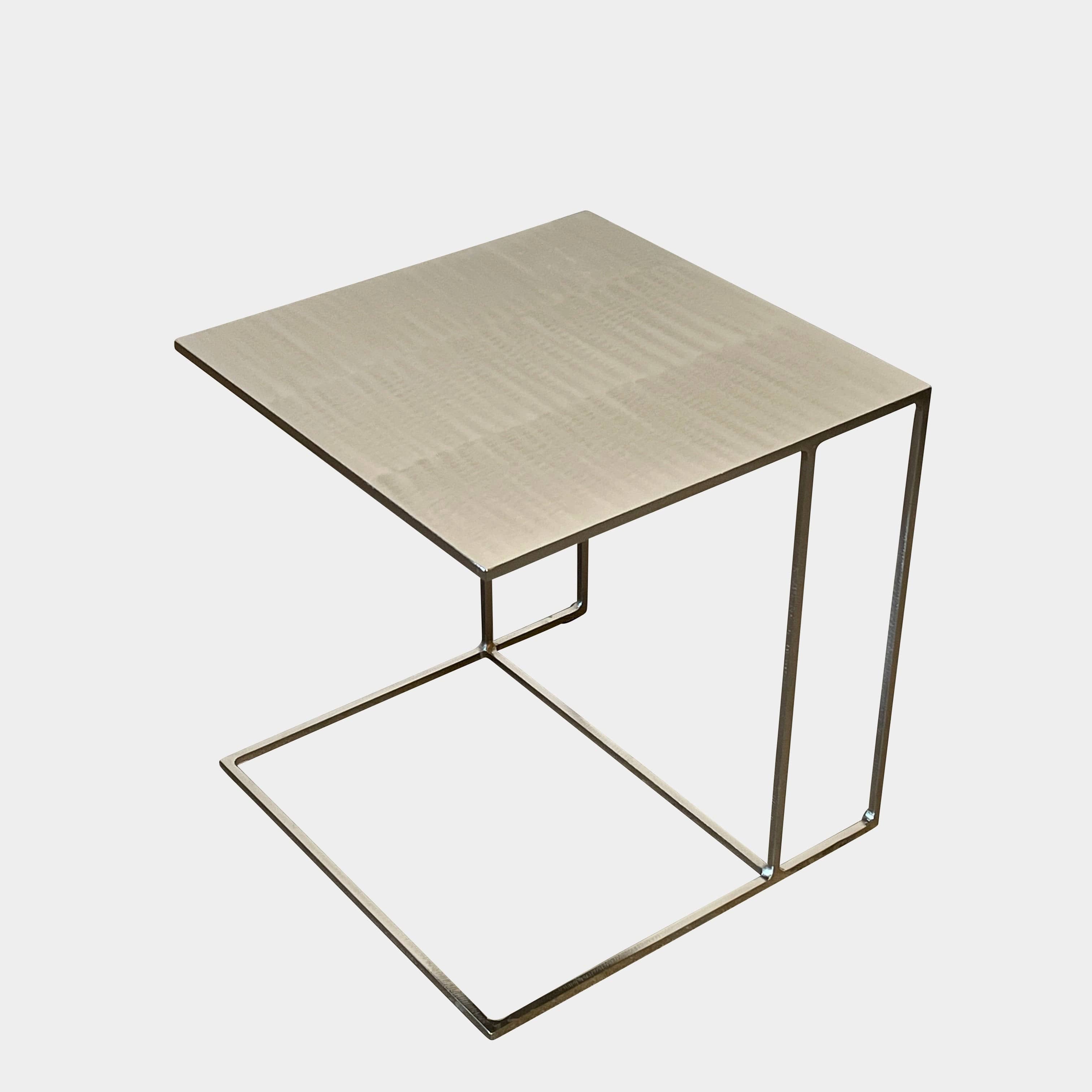 The Minotti Leger Side Table, by Minotti, features a metallic accent with its metal frame, creating a clean and minimal design against a white background.