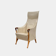 The Giorgetti “Progetti” Bergère / High-Back Lounge Chair by Giorgetti features light beige upholstery, wooden armrests and legs, and elegant ivory saddle leather accents, all inspired by the sophisticated Progetti collection, and is showcased against a plain white background.