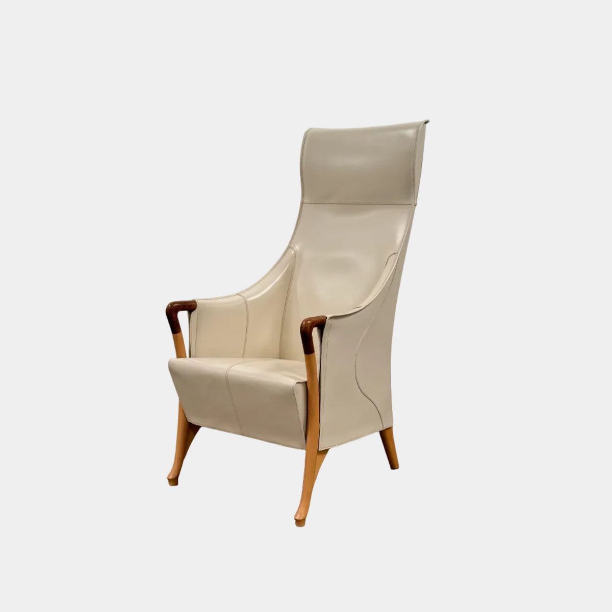 The Giorgetti “Progetti” Bergère / High-Back Lounge Chair by Giorgetti features light beige upholstery, wooden armrests and legs, and elegant ivory saddle leather accents, all inspired by the sophisticated Progetti collection, and is showcased against a plain white background.