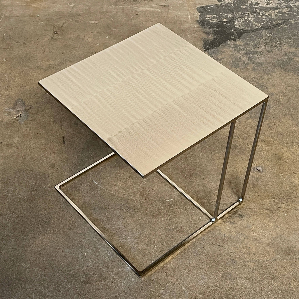 The Minotti Leger Side Table, by Minotti, features a metallic accent with its metal frame, creating a clean and minimal design against a white background.