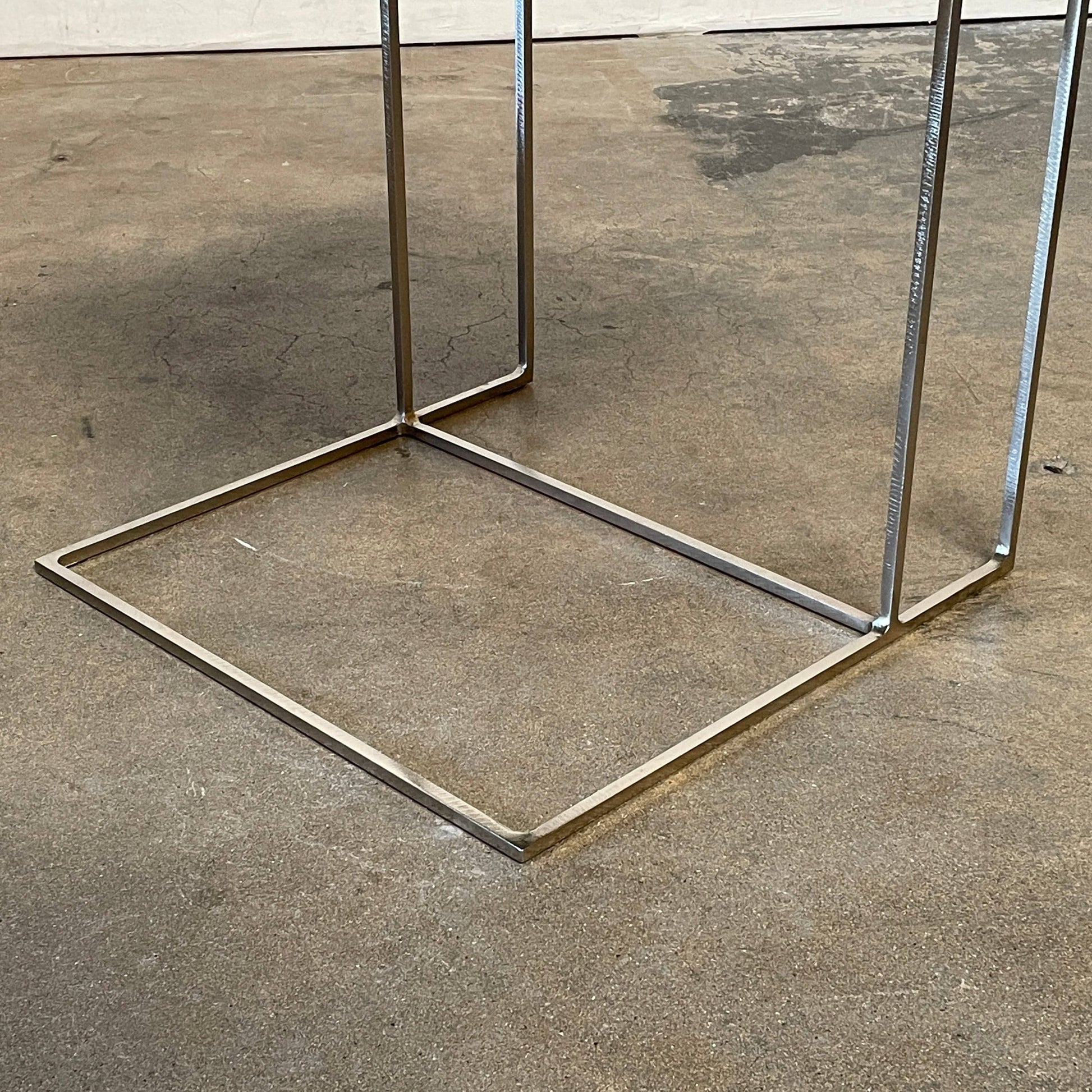 The Minotti Leger Side Table, by Minotti, features a metallic accent with its metal frame, creating a clean and minimal design against a white background.