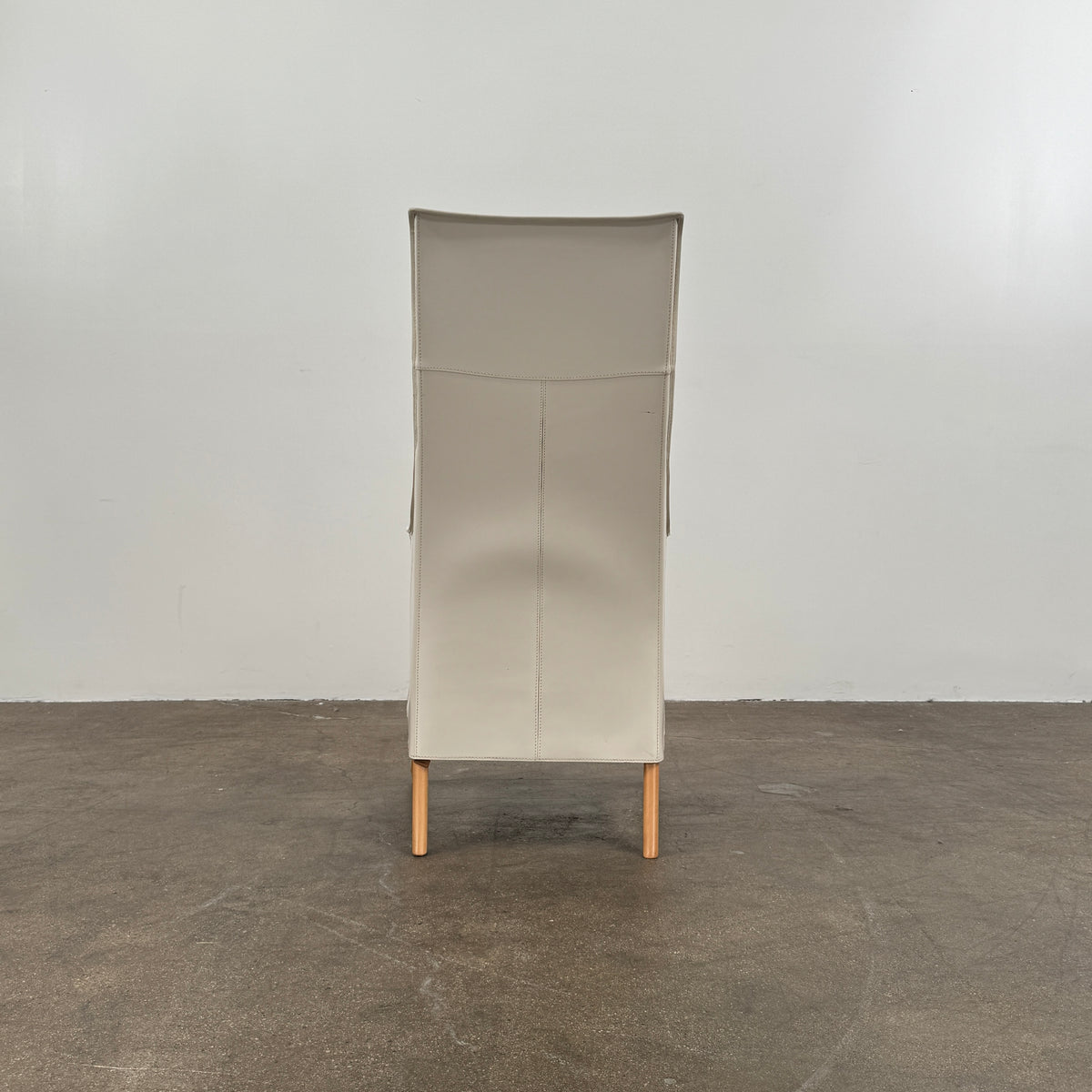 The Giorgetti “Progetti” Bergère / High-Back Lounge Chair by Giorgetti features light beige upholstery, wooden armrests and legs, and elegant ivory saddle leather accents, all inspired by the sophisticated Progetti collection, and is showcased against a plain white background.