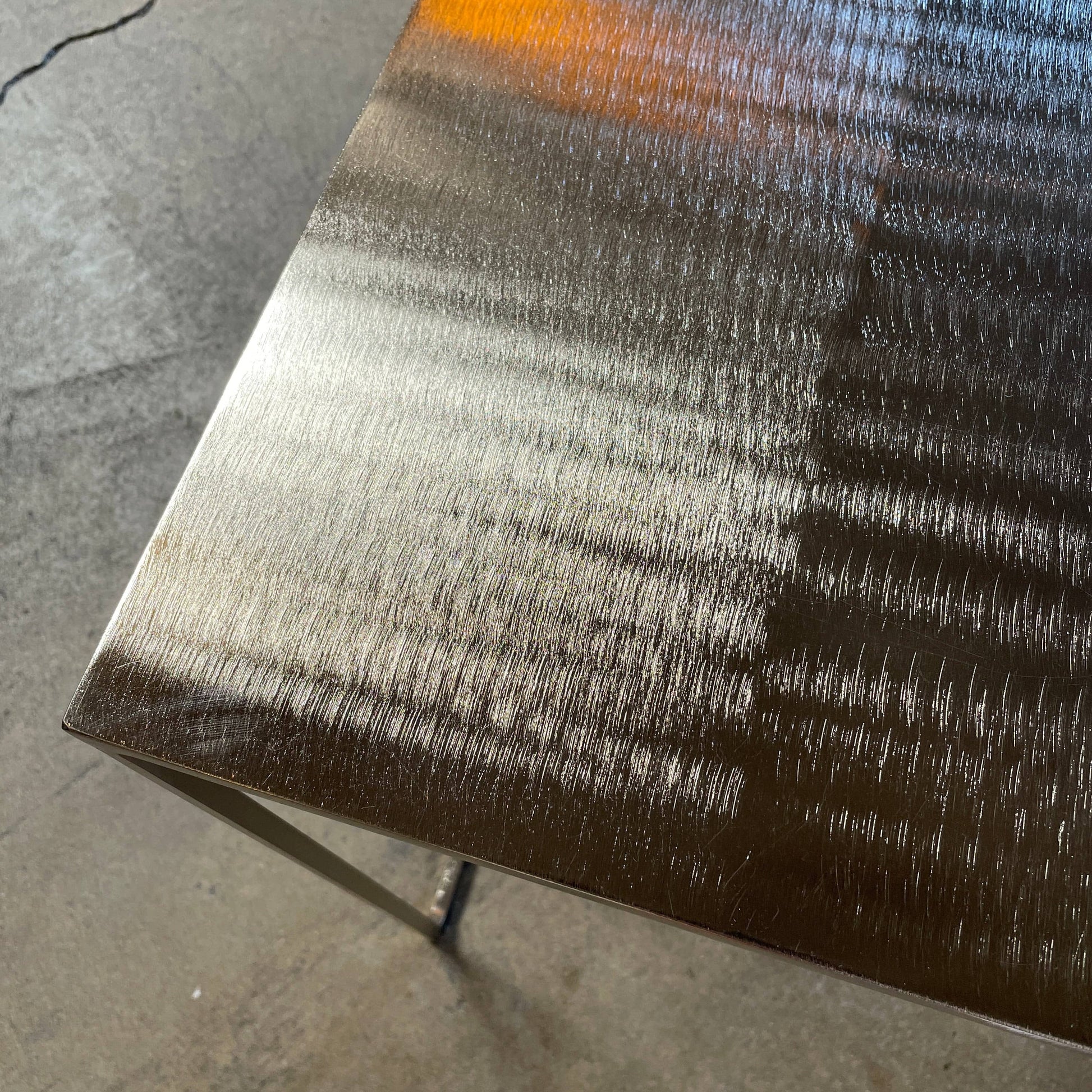 The Minotti Leger Side Table, by Minotti, features a metallic accent with its metal frame, creating a clean and minimal design against a white background.