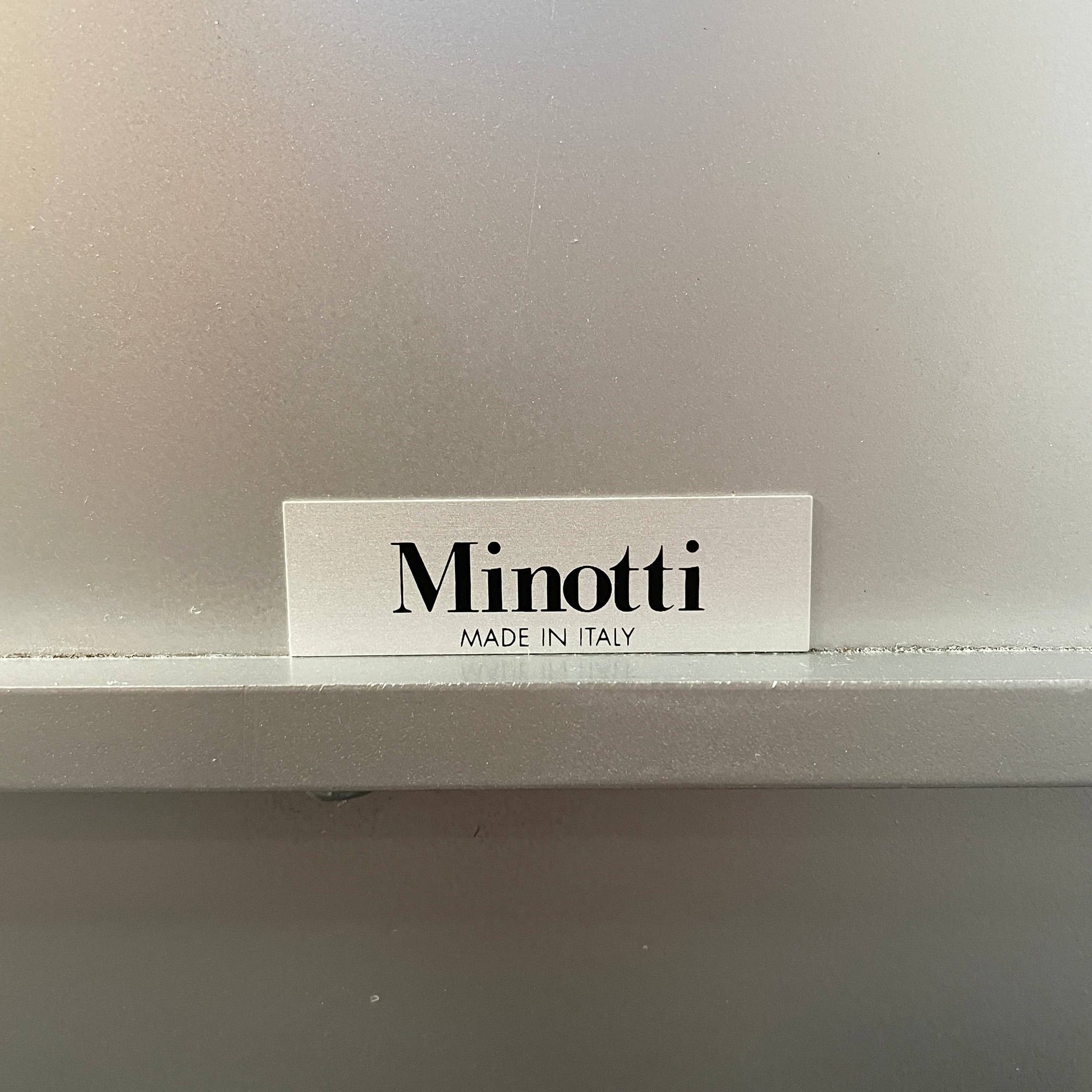 The Minotti Leger Side Table, by Minotti, features a metallic accent with its metal frame, creating a clean and minimal design against a white background.